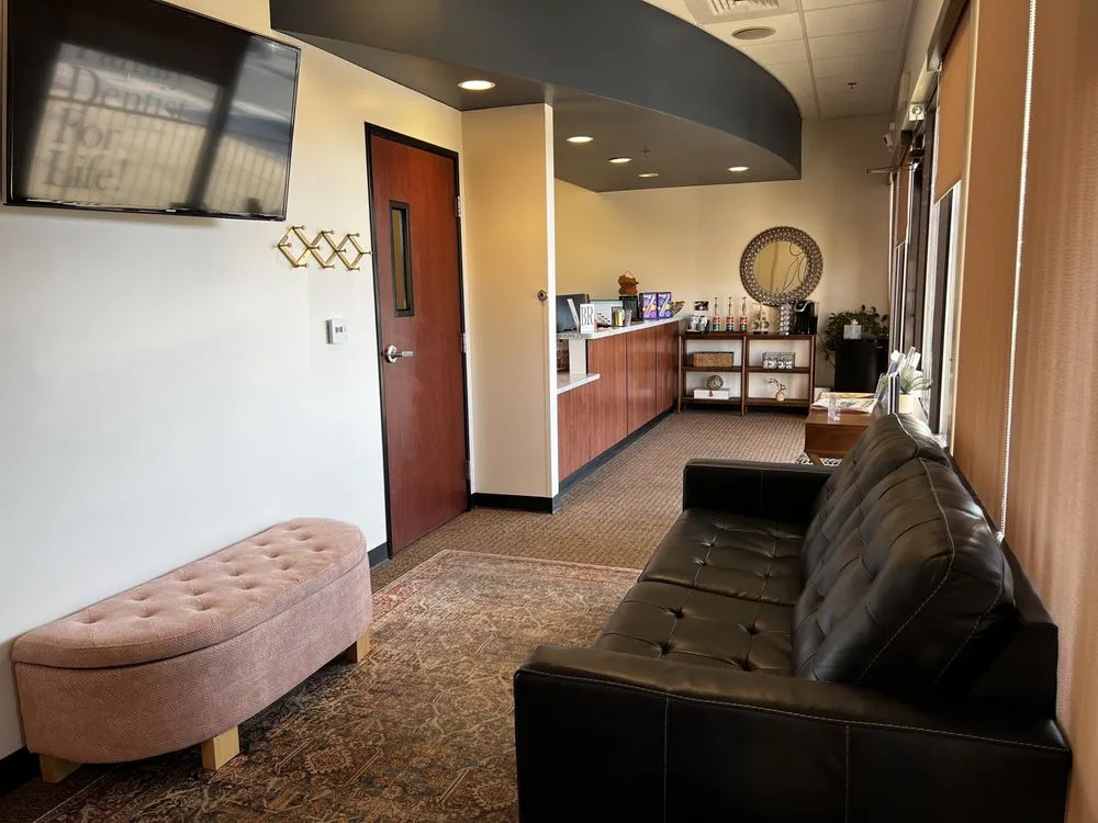 Modern dental office reception area with comfortable seating front desk large windows and a warm welcoming environment for dental patients