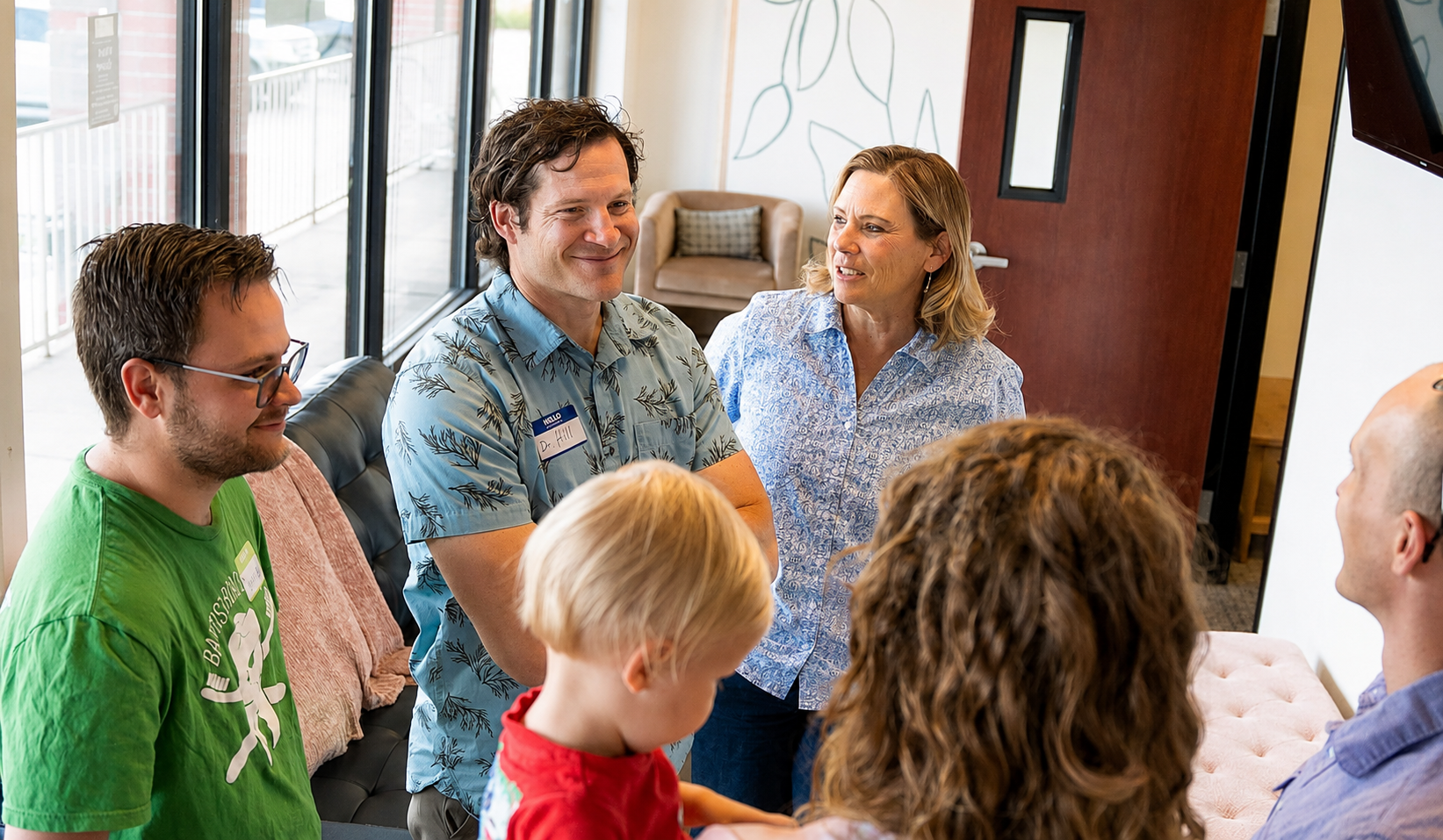 Dr. Hill greeting and chatting with a family in the reception area of Advanced Dental & Implant Center's office.