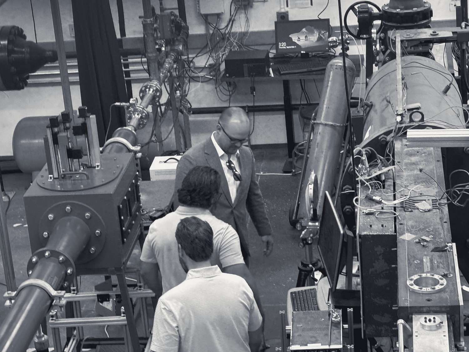 Service members examine equipment in a lab