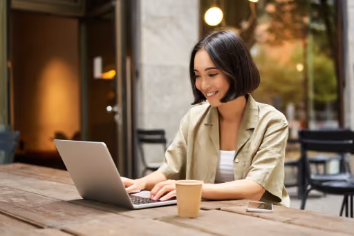 Selbstständige Freiberuflerin arbeitet mit Laptop in einem Café