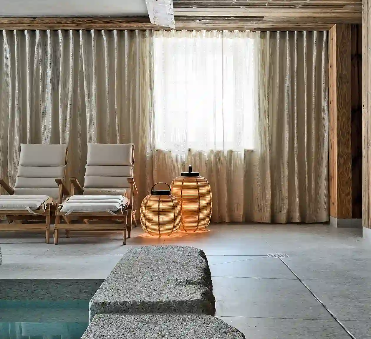 Intérieur de l'espace bien-être avec des chaises longues, une piscine et de grandes baies vitrées, La Ferme des Drus, Chamonix-Mont-Blanc, France.
