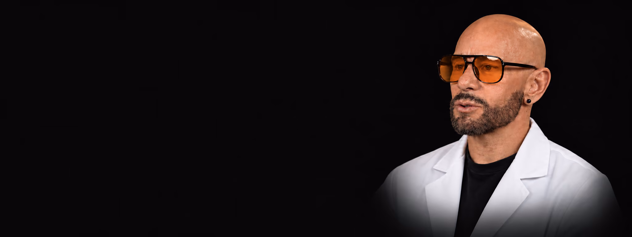 Juan Salcedo, founder of Nexsis BioHealth, in a white lab coat against a dark background