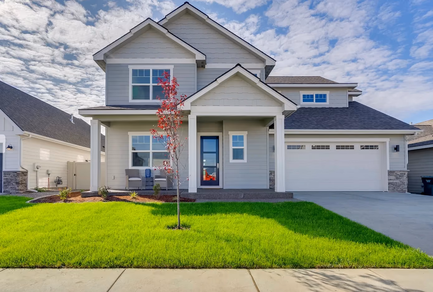 Two-story craftsman home with covered porch and three-car garage