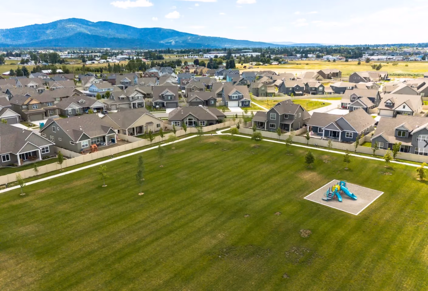 Aerial view of the neighborhood park, recreation lawn, and mountains beyond