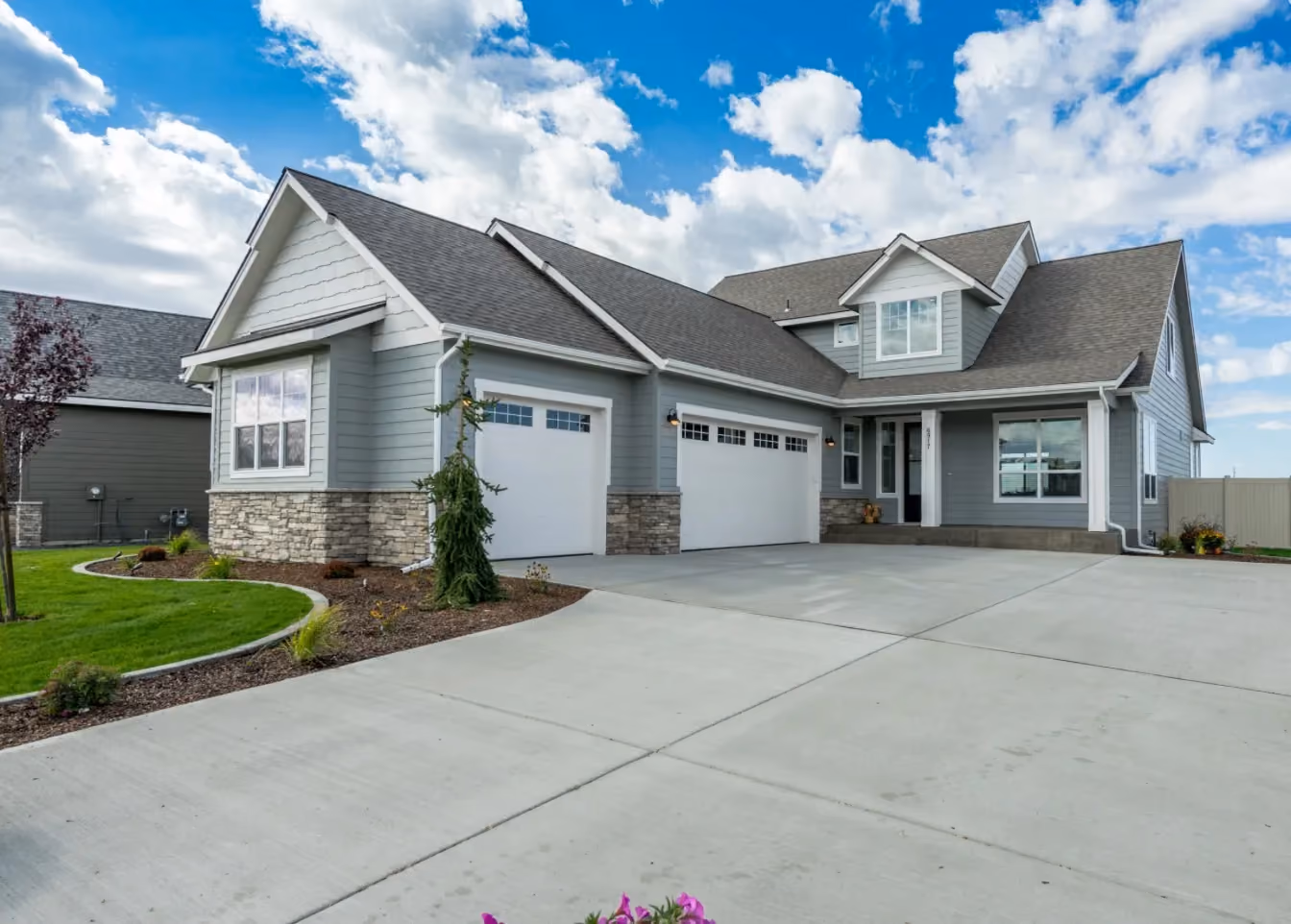 Craftsman home with stone wainscot and three-car garage