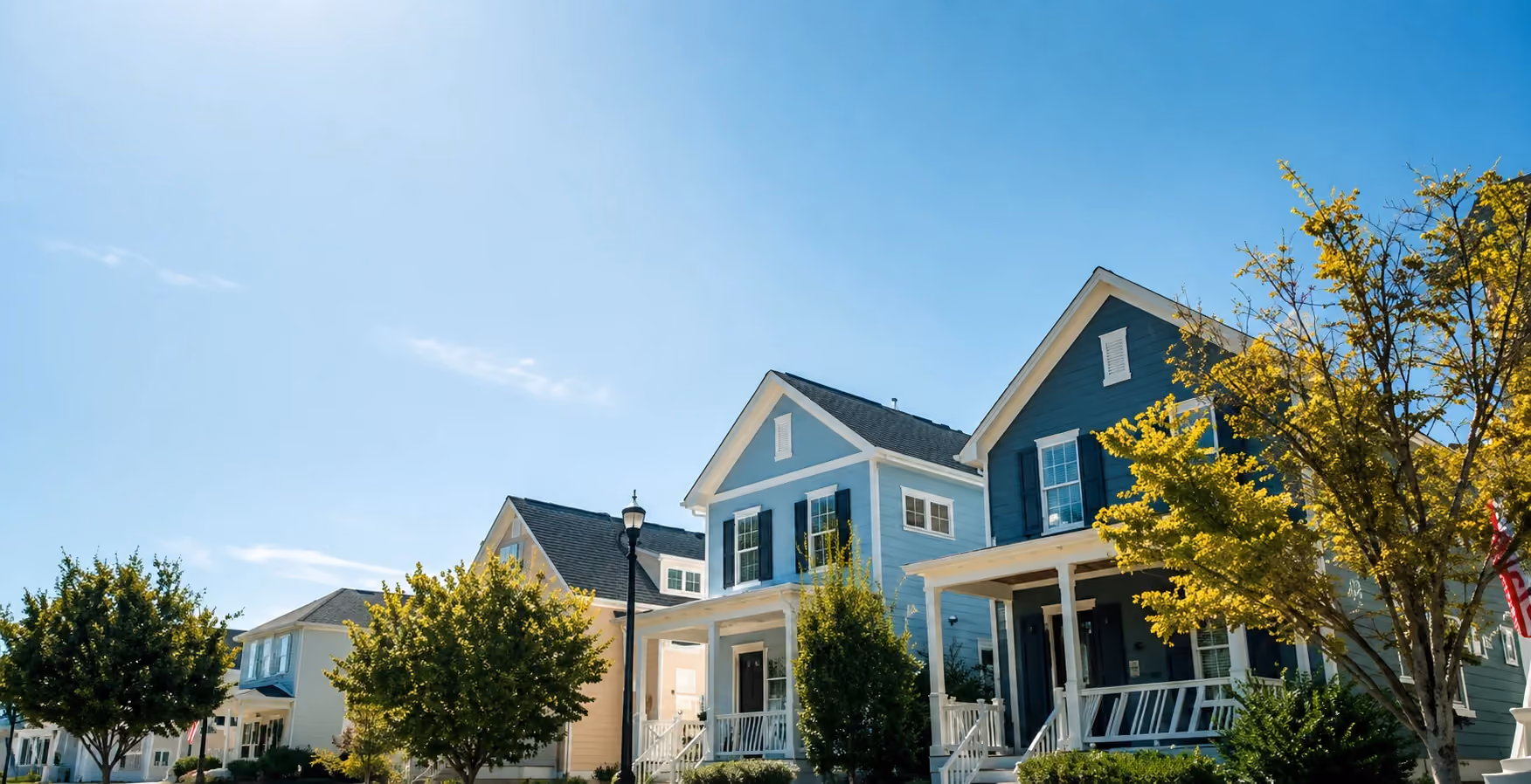 Homes with covered front porches along a tree-lined street at The Post in Post Falls, Idaho