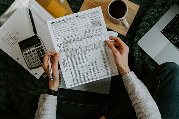 Photo of a person holding a tax form, by Kelly Sikkema.