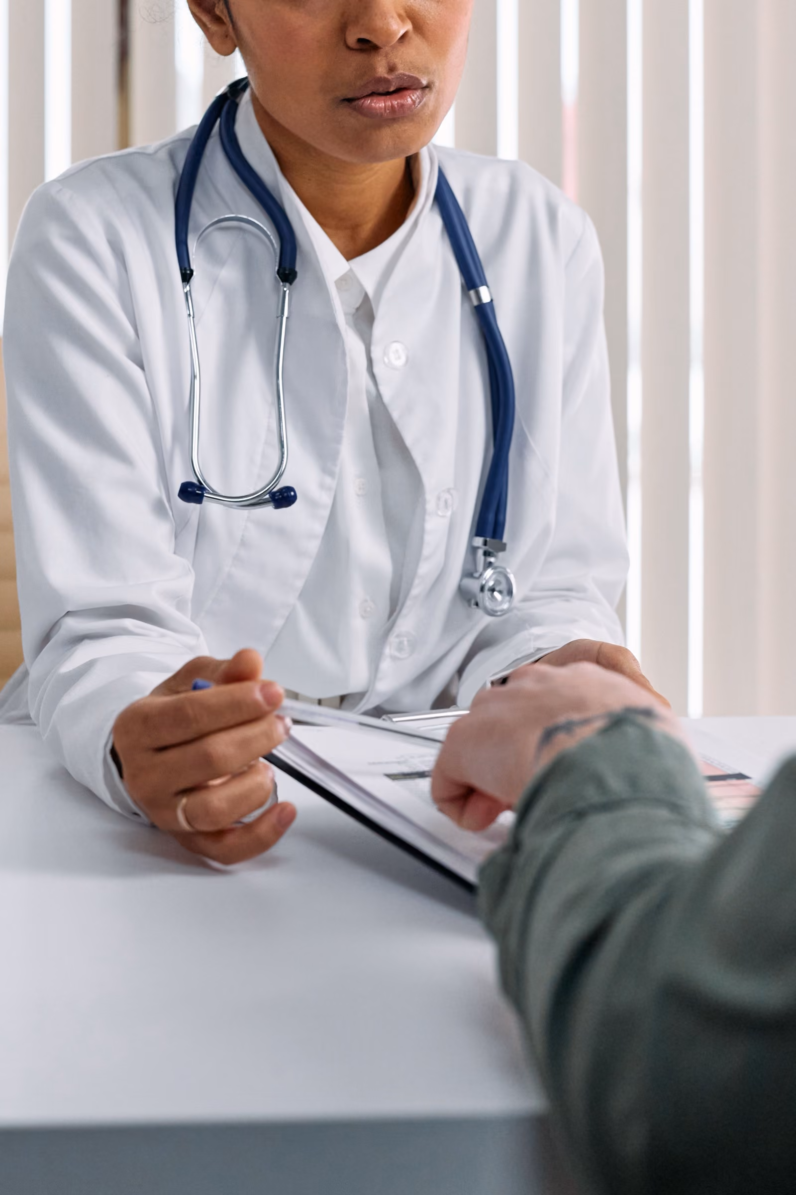 Clinic staff consulting with a patient at a table