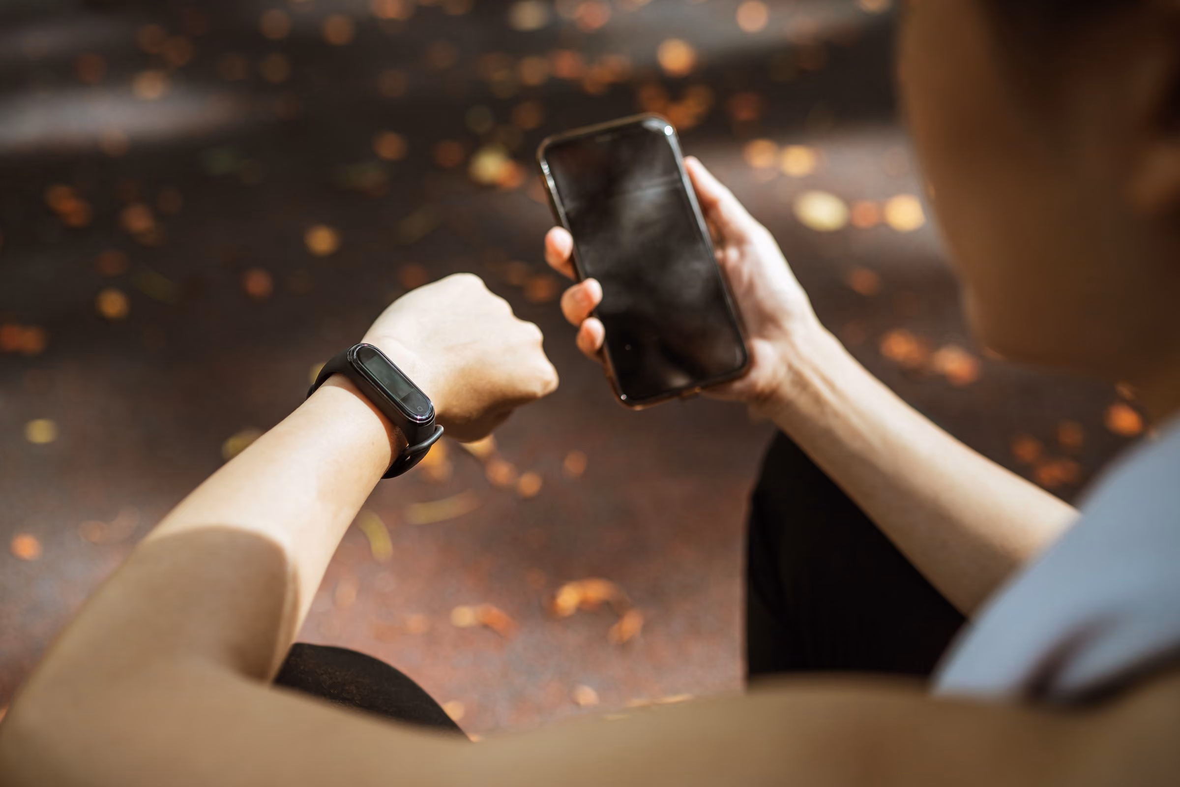 Person tracking their health on a phone and wearable