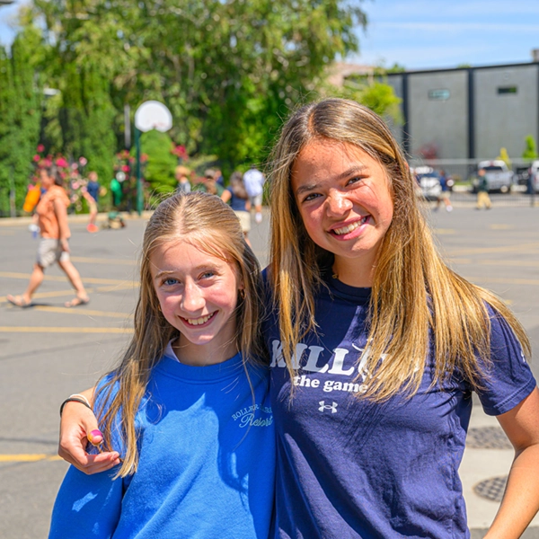 Two students smiling outdoors on the schoolyard at St. Joseph Marquette Catholic School in Yakima