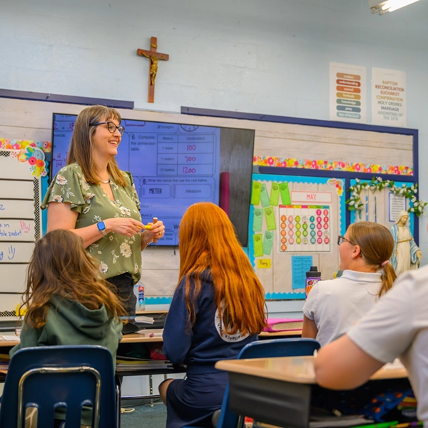 A teacher leading a lesson beneath a crucifix in a classroom at St. Joseph Marquette Catholic School in Yakima