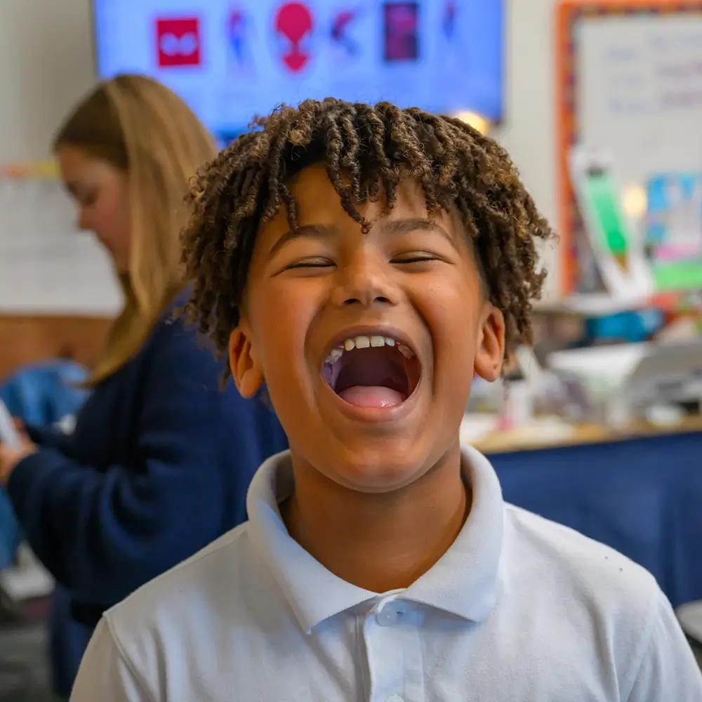 A student laughing joyfully in class at St. Joseph Marquette Catholic School in Yakima