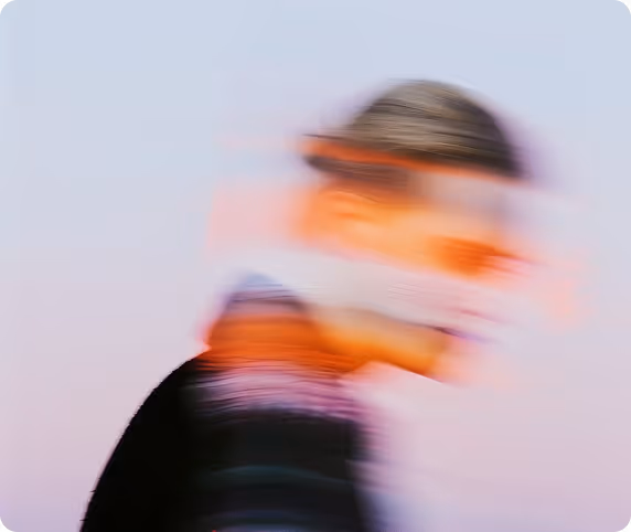 Blurred side profile of a person with motion distortion against a light purple background.