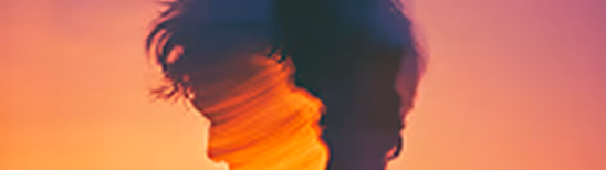 Double exposure silhouette of a person with warm, colorful gradient background.