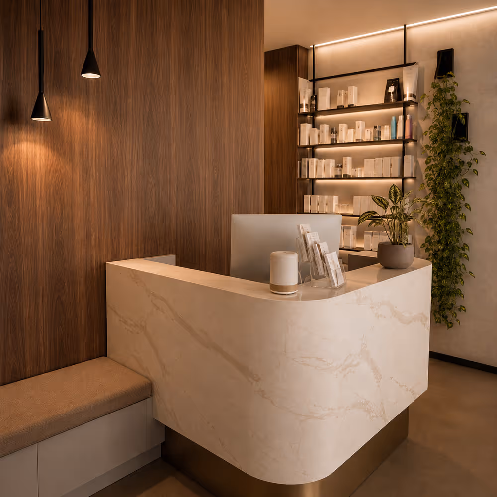 Modern spa reception with marble desk, wooden walls, product shelves, plants, and warm lighting.