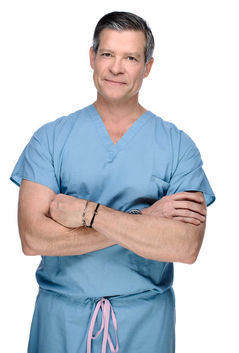 Dr Mills wearing scrubs, standing with arms crossed