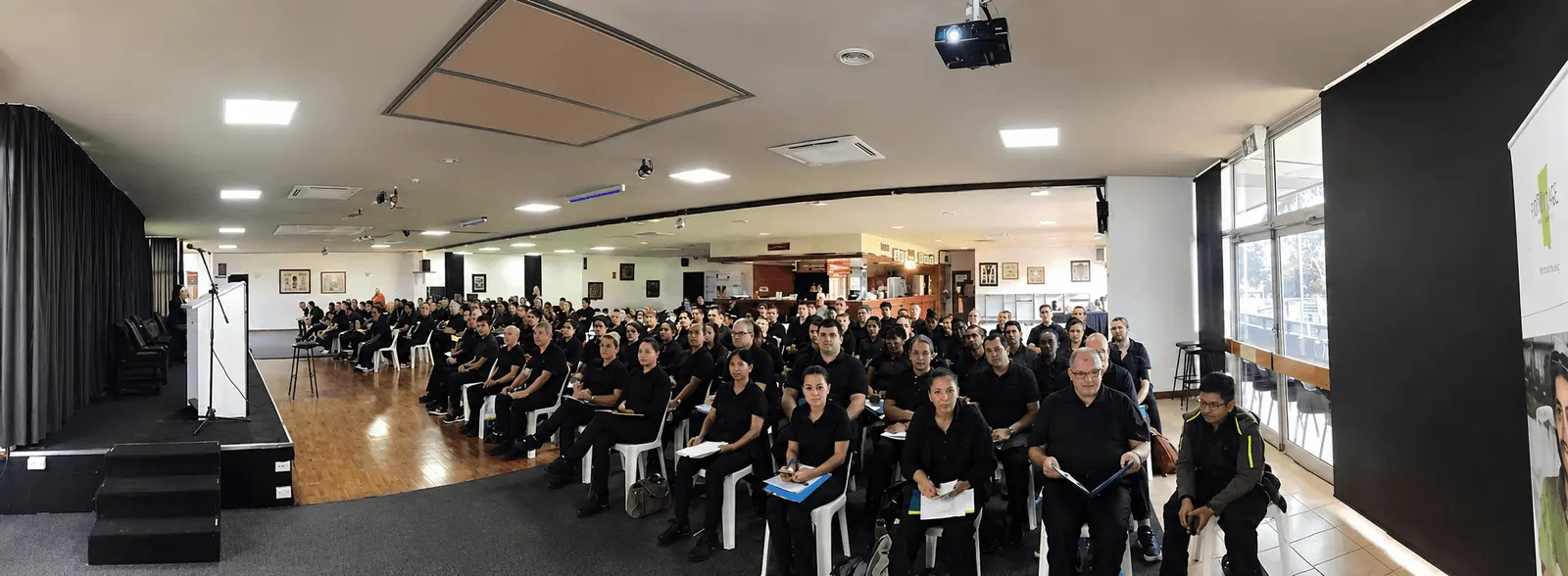 Front Age workforce induction session, large group seated in a training hall