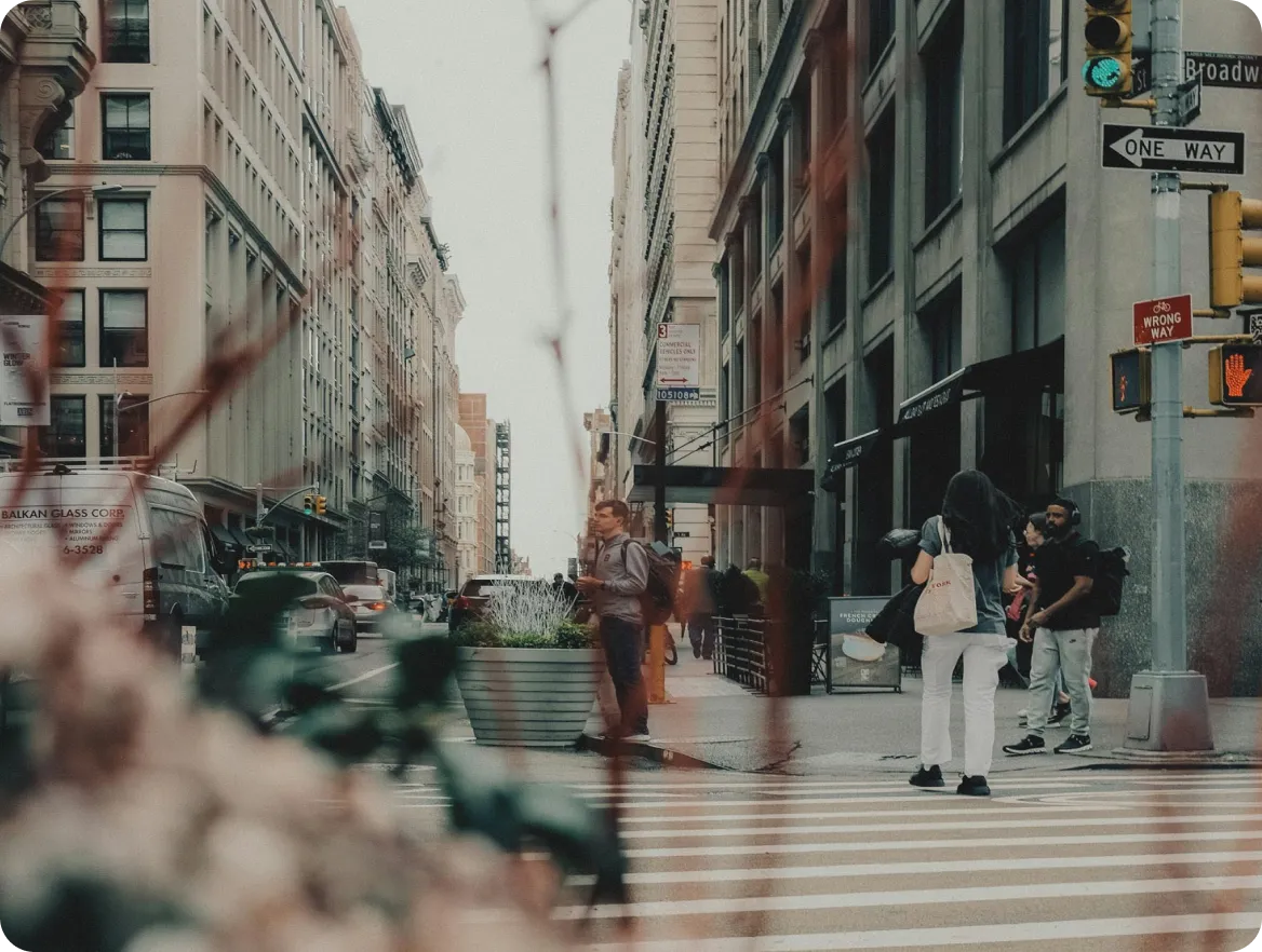 A busy street corner in Seattle with pedestrians crossing and traffic signage in view.