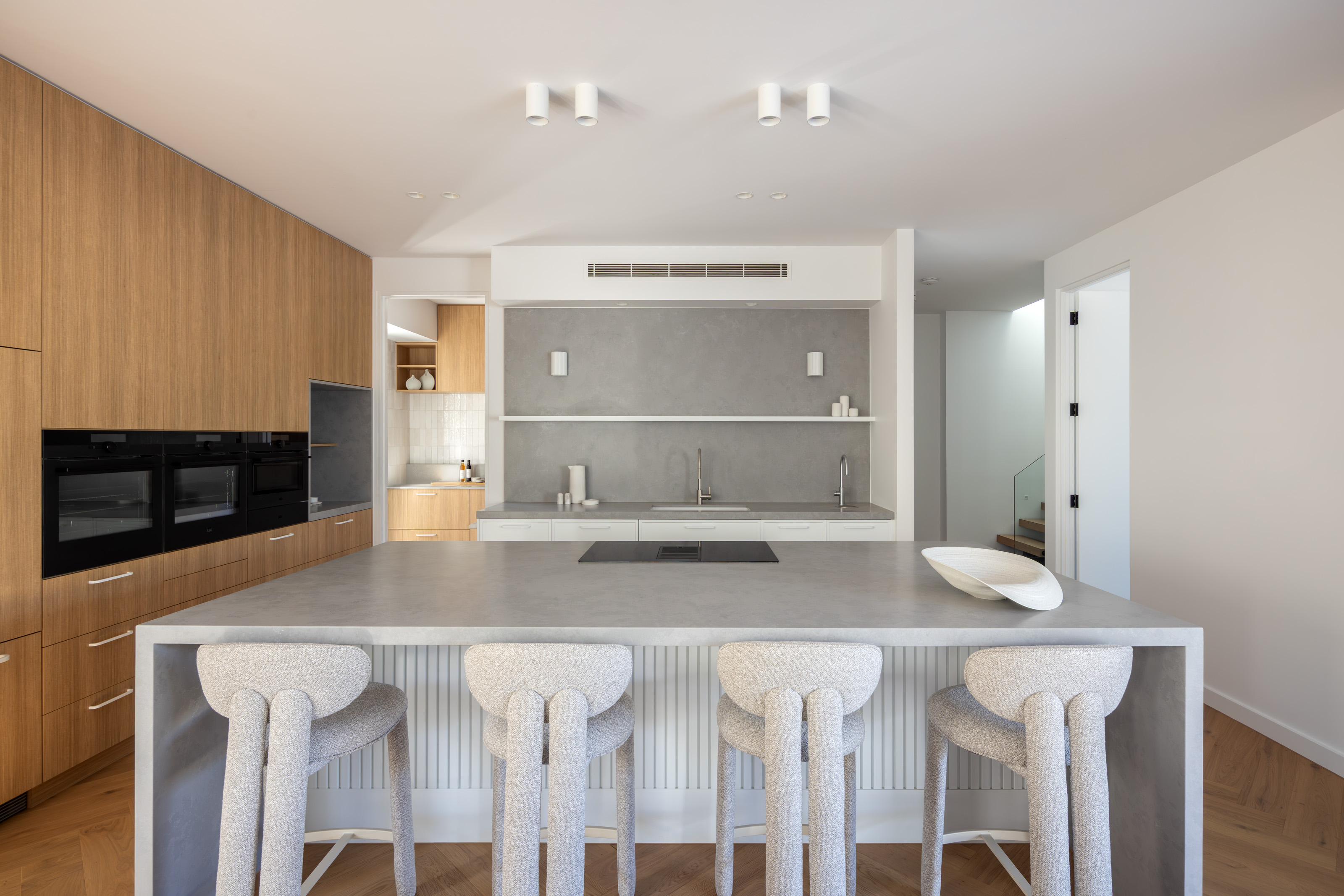 Open-plan kitchen with stone island bench and timber joinery at 54 North Adelaide.