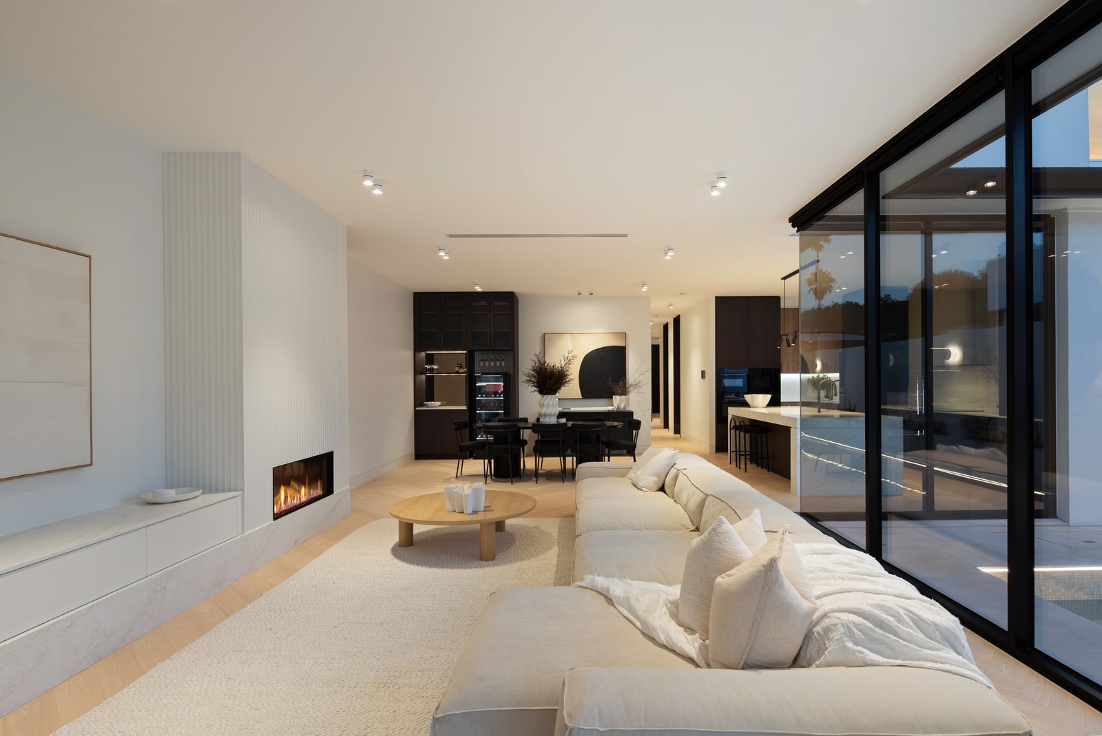 Open-plan living and kitchen opening to the pool terrace in a completed AP Designer Homes custom home.