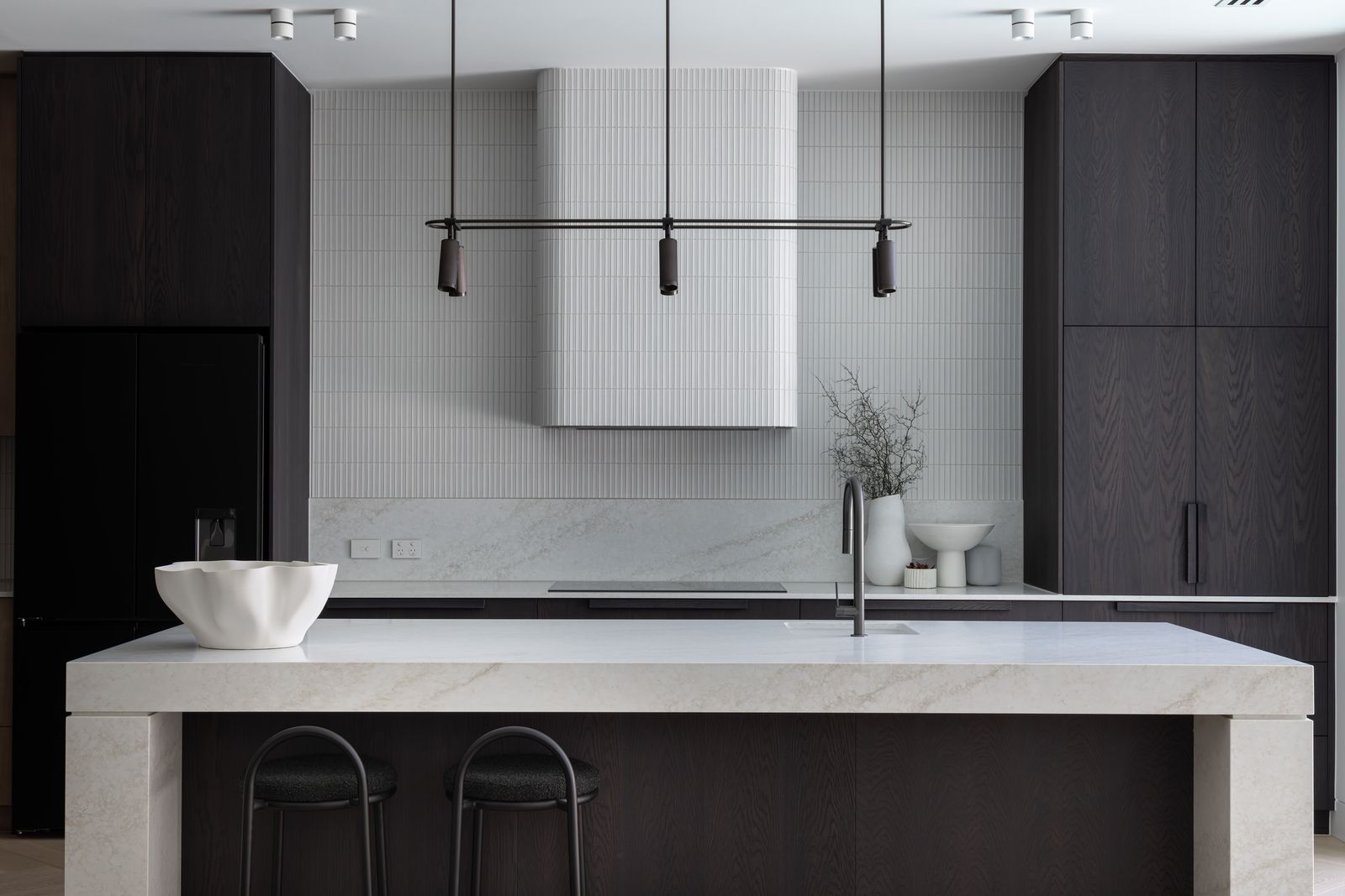 Custom kitchen with stone island, fluted joinery and integrated lighting in a completed AP Designer Homes home.