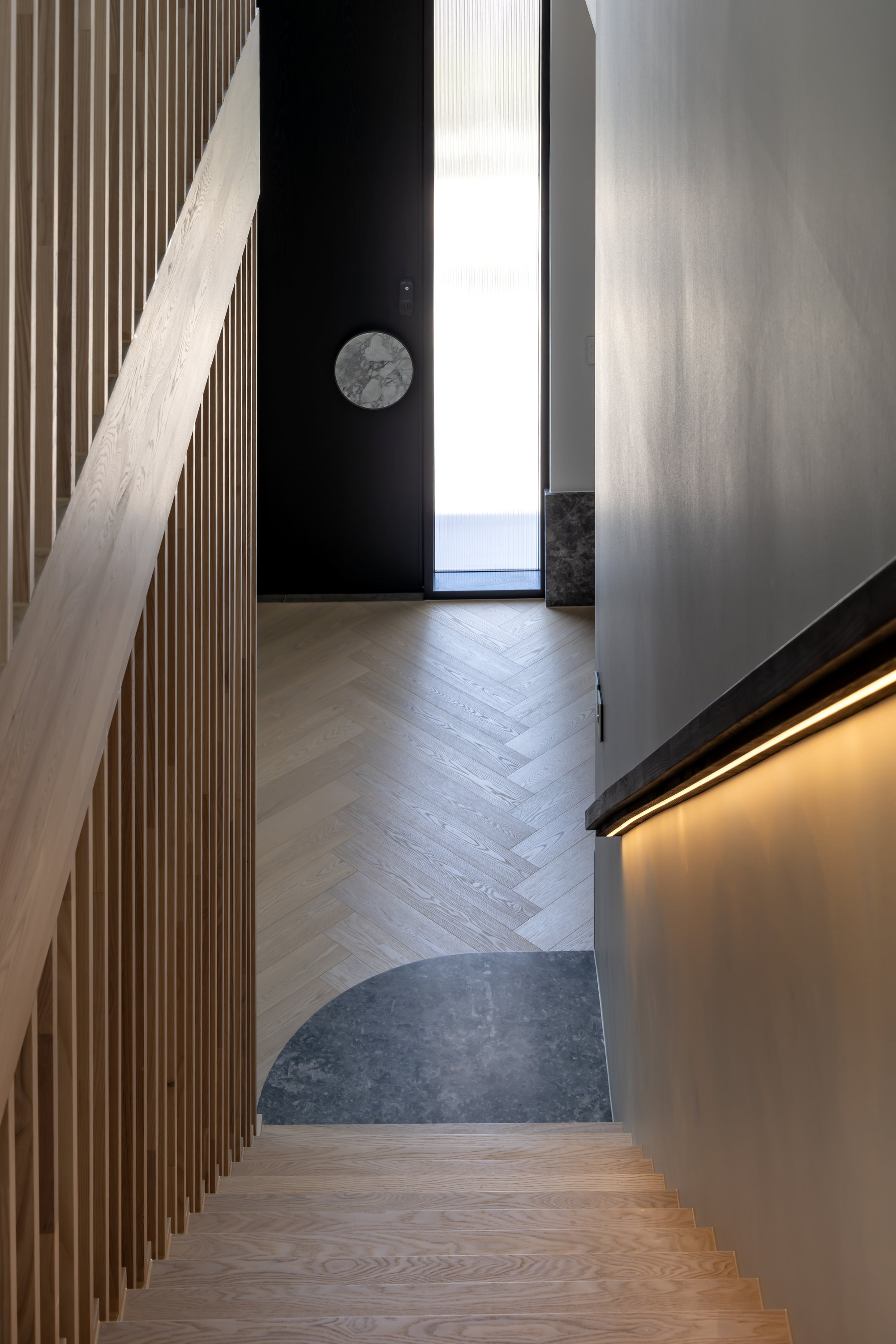Looking down the oak stair to the entry, with batten balustrade and concealed lighting at 9 Netherby
