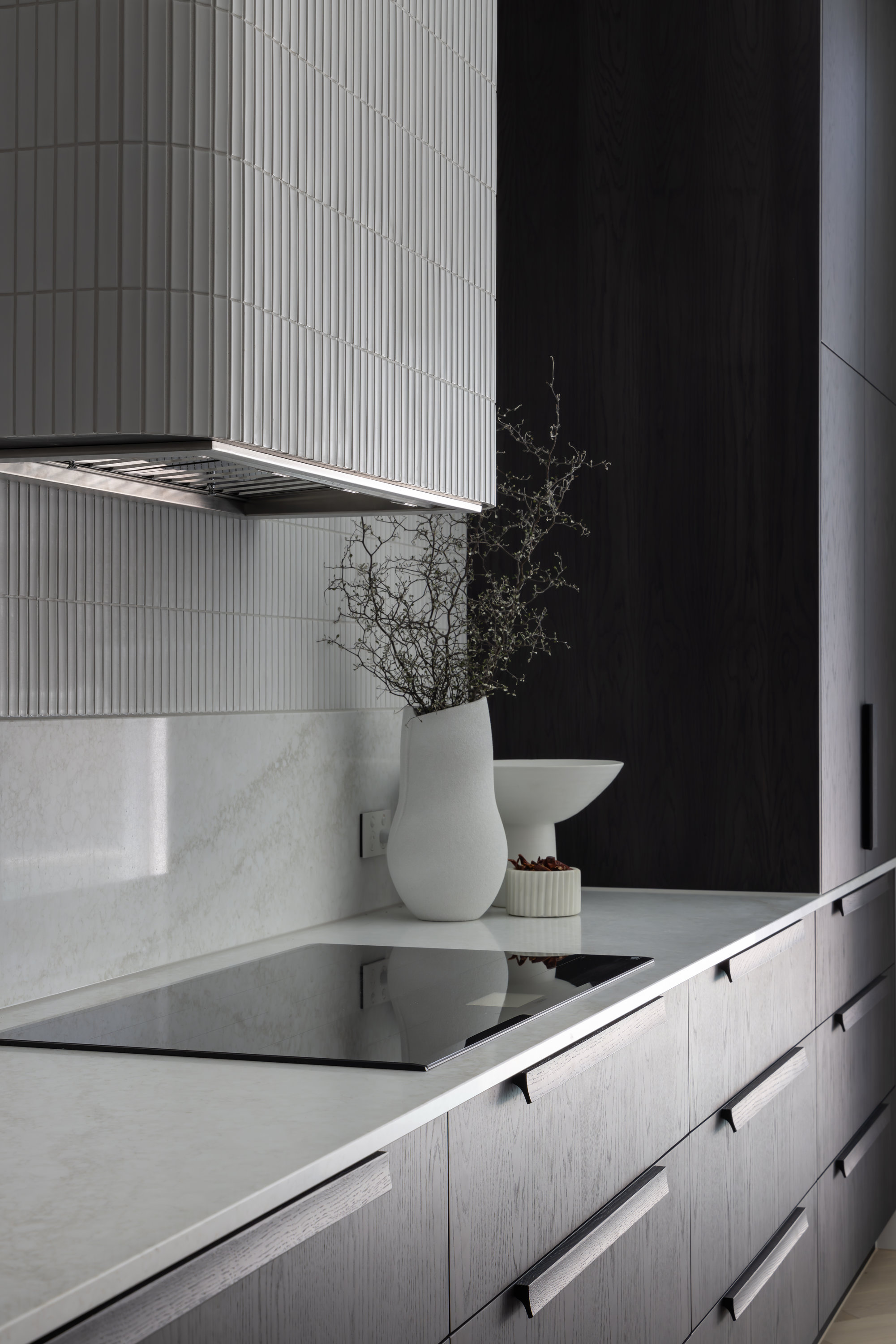 Fluted tile rangehood above the cooktop with stone splashback and oak drawers at 9 Netherby