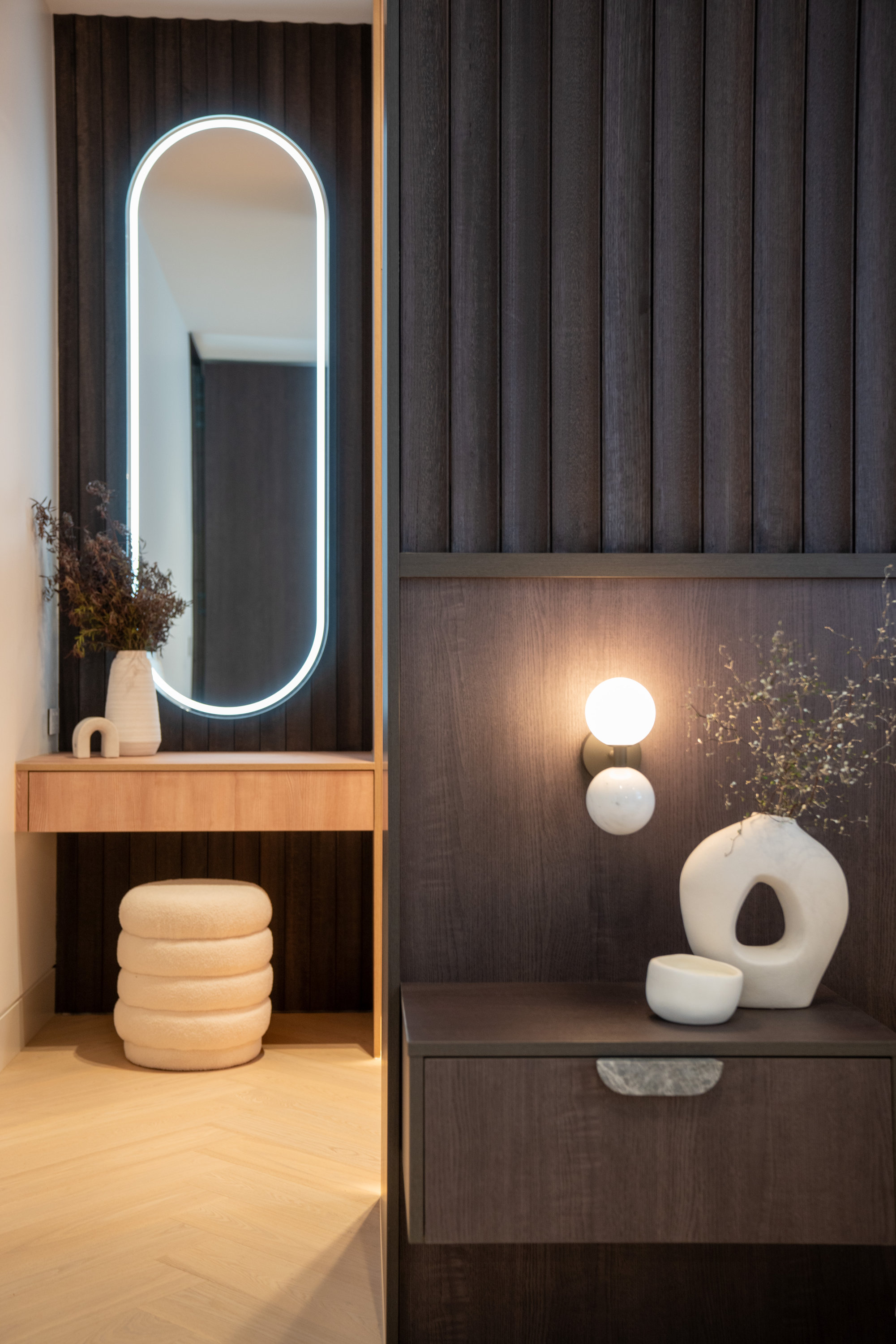 Dressing nook with backlit oval mirror, oak console and fluted timber panelling at 9 Netherby