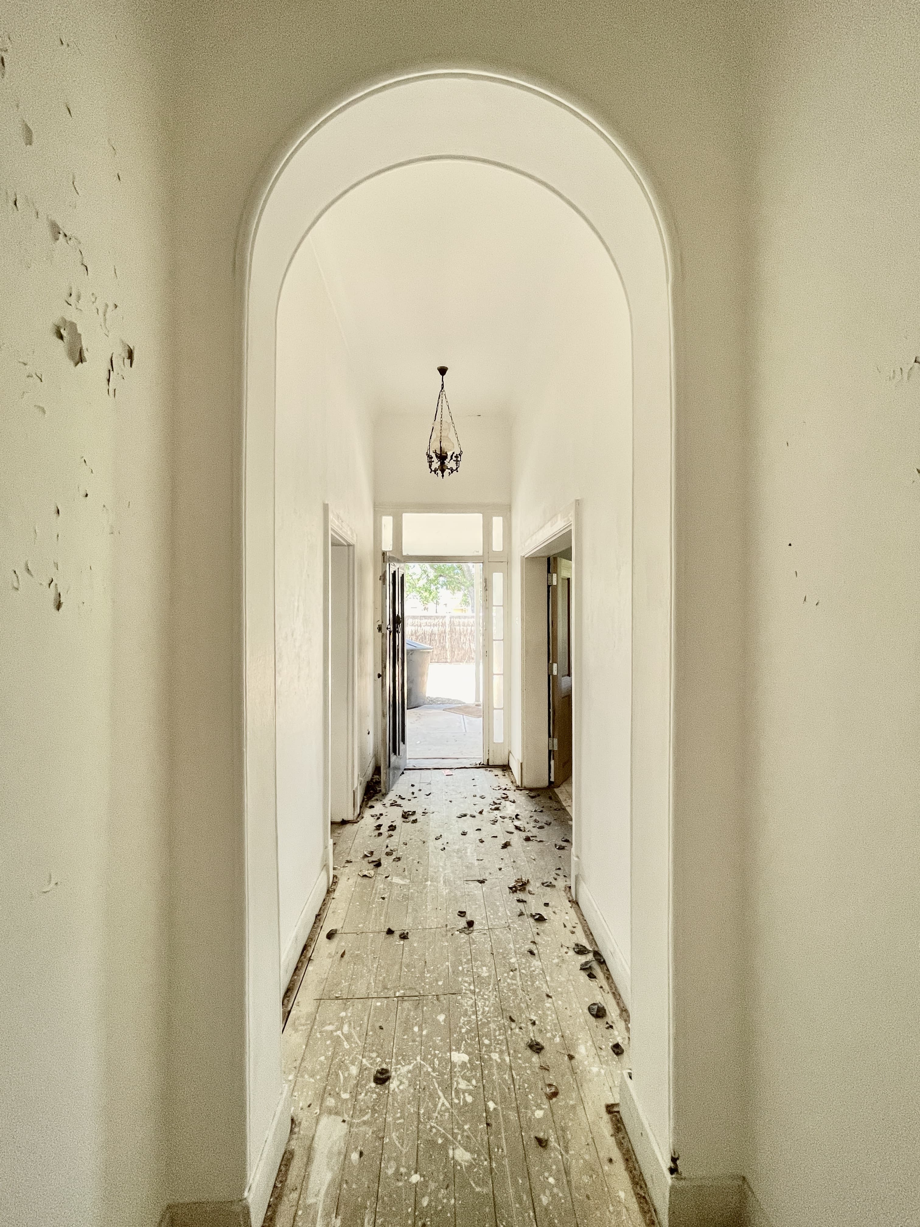 Original arched hallway at 54 North Adelaide before restoration, stripped back to timber floorboards