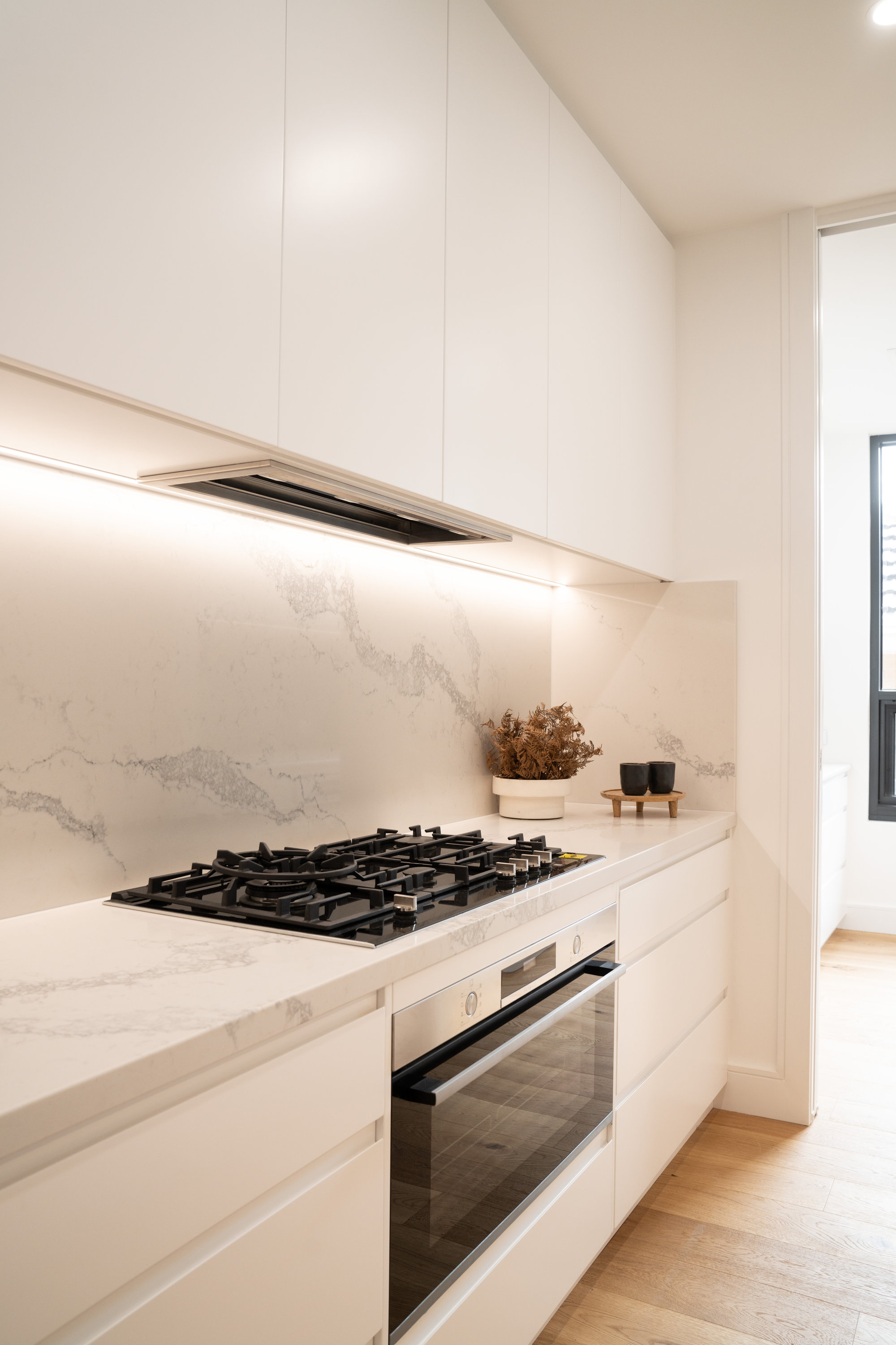 Gas cooktop and integrated oven beneath a marble splashback at 24 Wattle Park