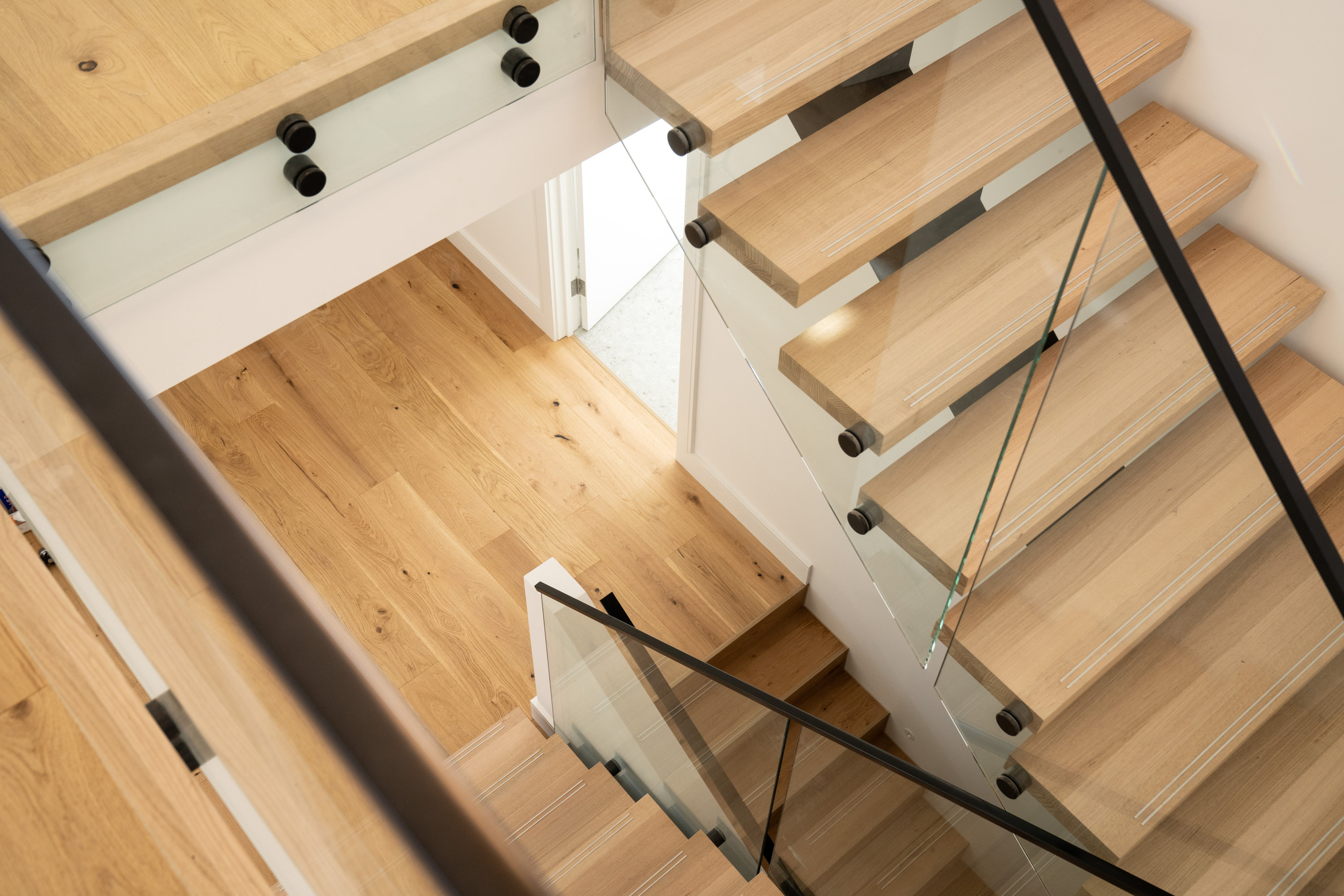 Oak staircase with glass balustrade viewed from the upper level at 24 Wattle Park