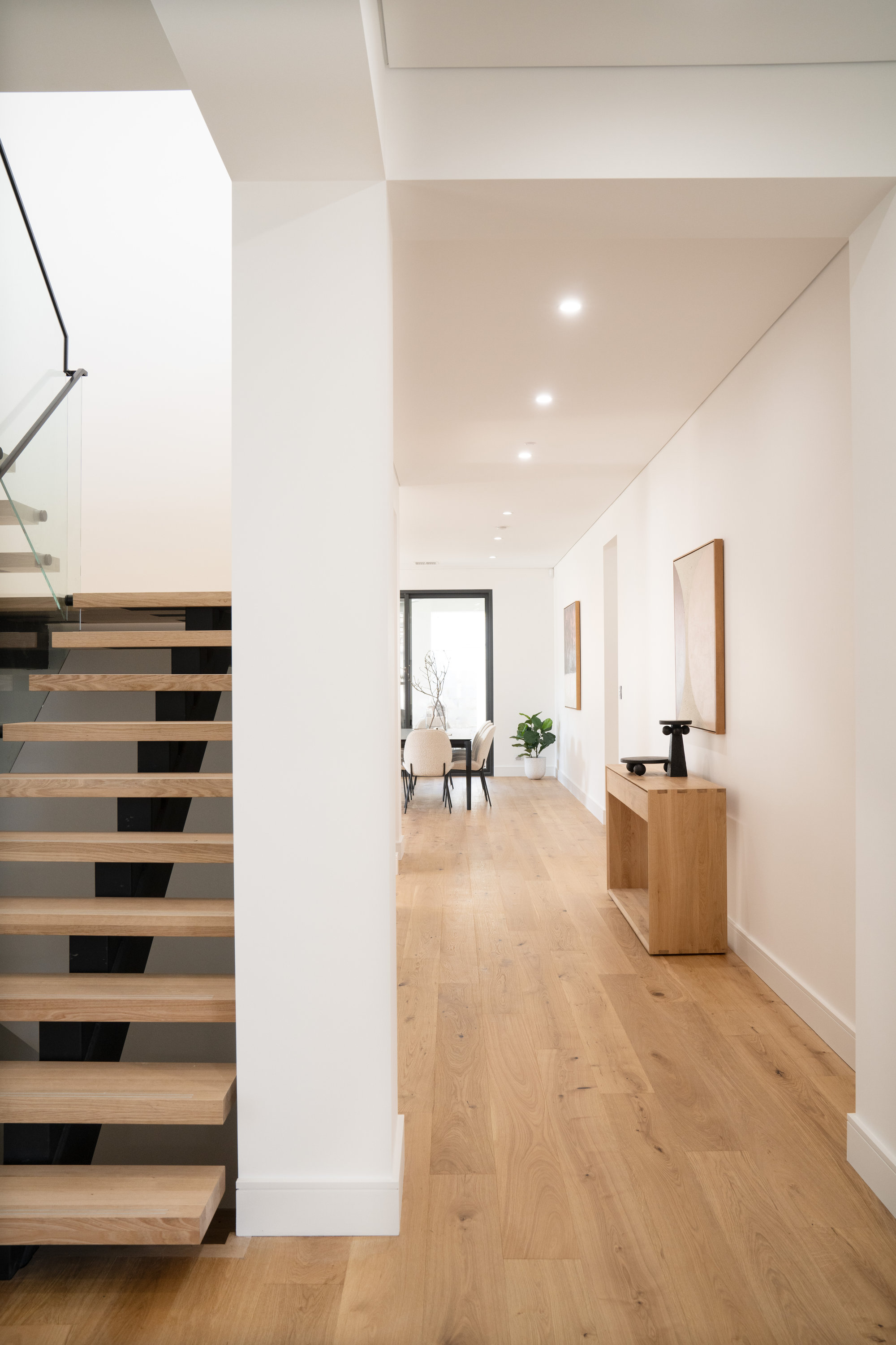 Entry hall and open-riser staircase looking through to the dining area at 24 Wattle Park