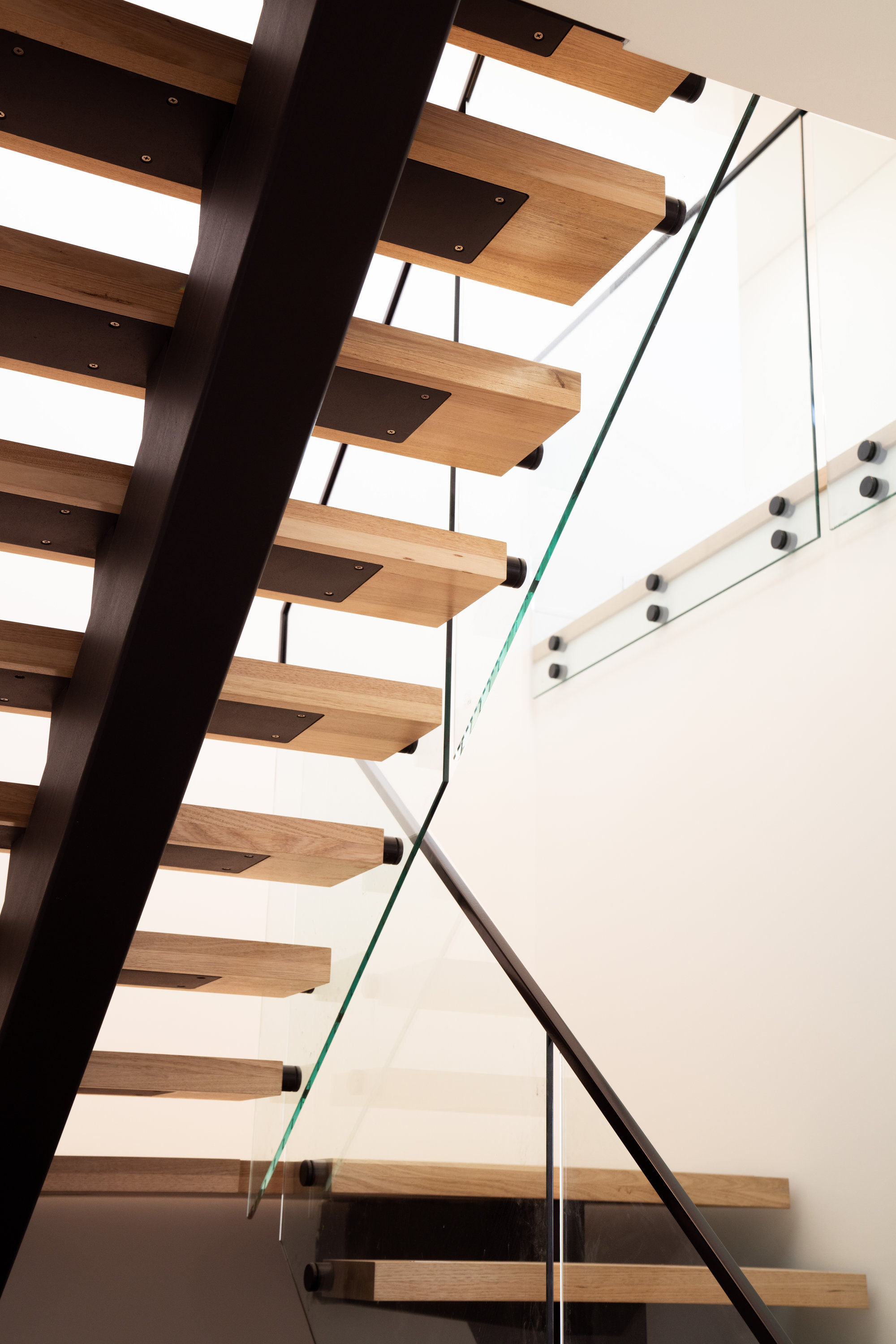Open-riser oak and steel staircase with glass balustrade at 24 Wattle Park