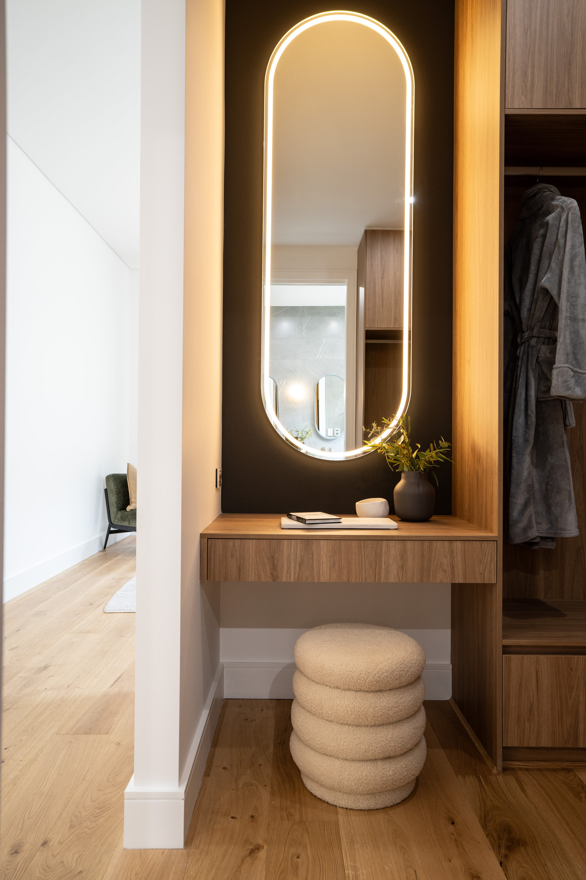 Dressing nook with backlit oval mirror, timber console and boucle stool at 24 Wattle Park