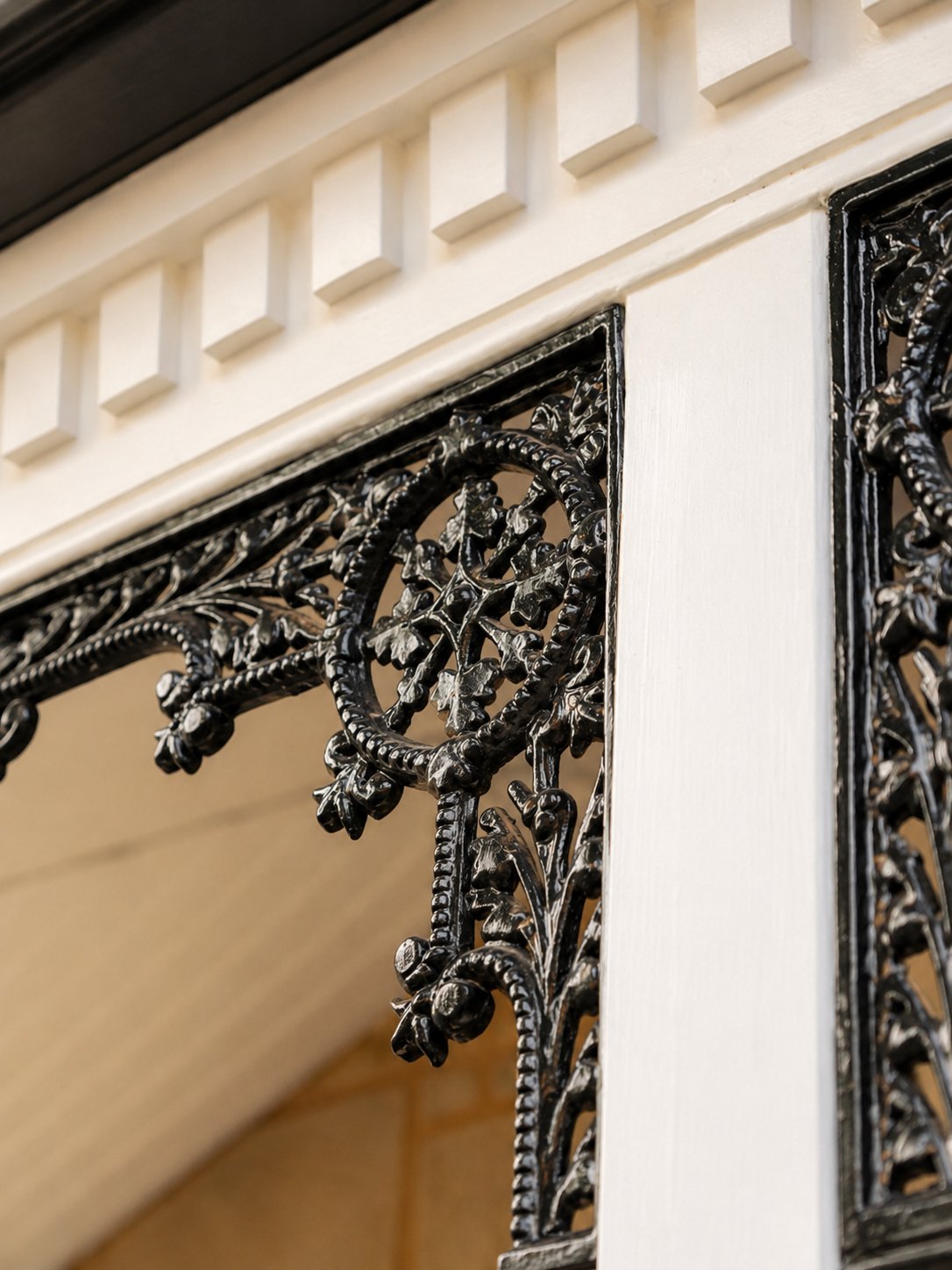 Cast-iron lacework bracket beneath a dentil-moulded verandah cornice at 21 Norwood