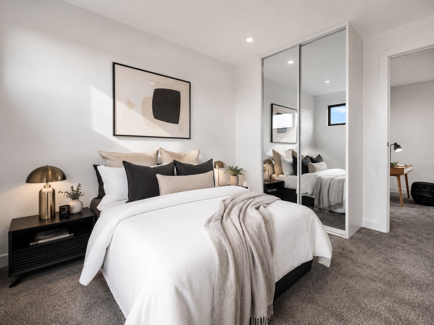 Bedroom with mirrored built-in robe, artwork and a black bedside table at 1 Magill