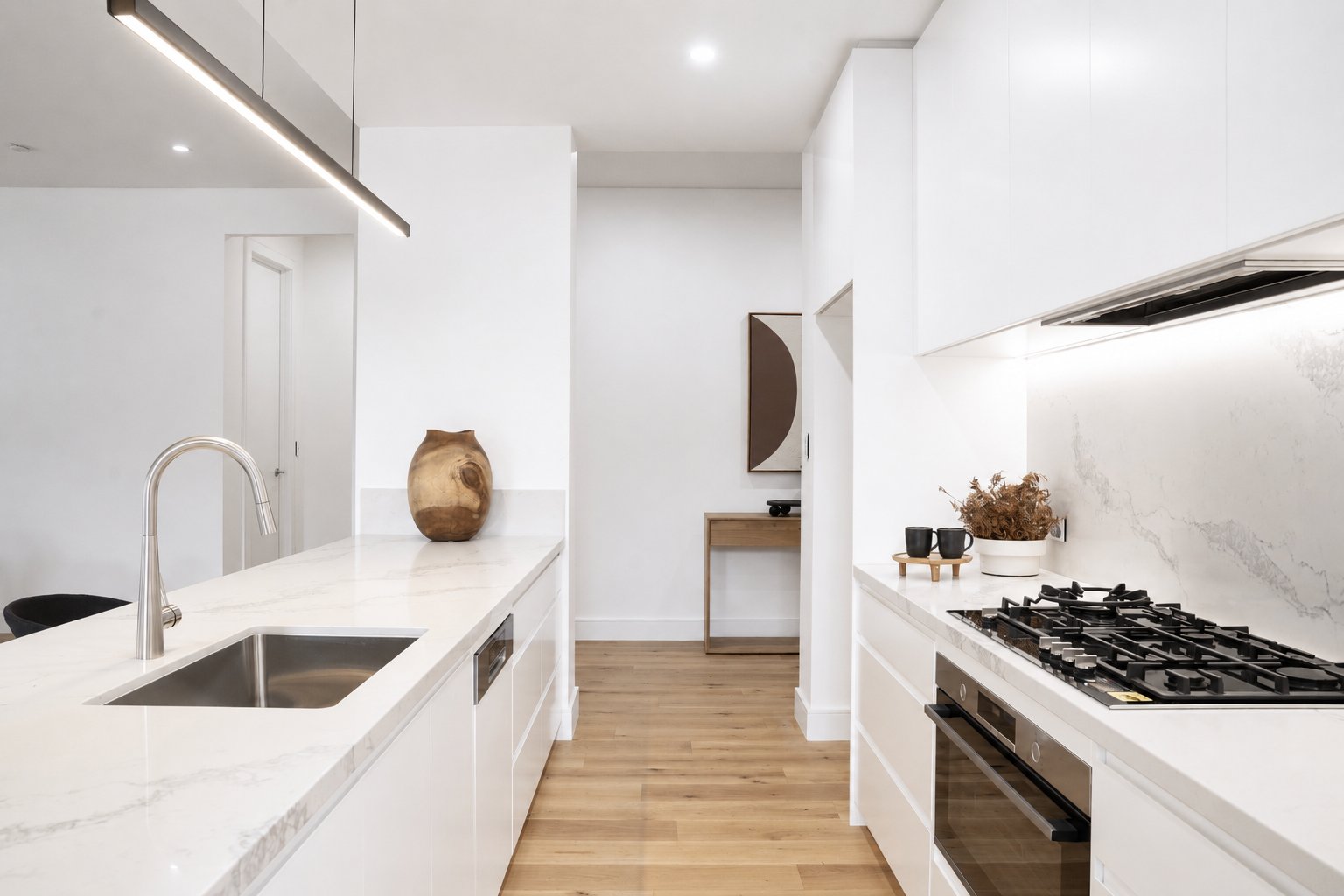 Galley kitchen with marble benchtops, undermount sink and oak flooring at 24 Wattle Park