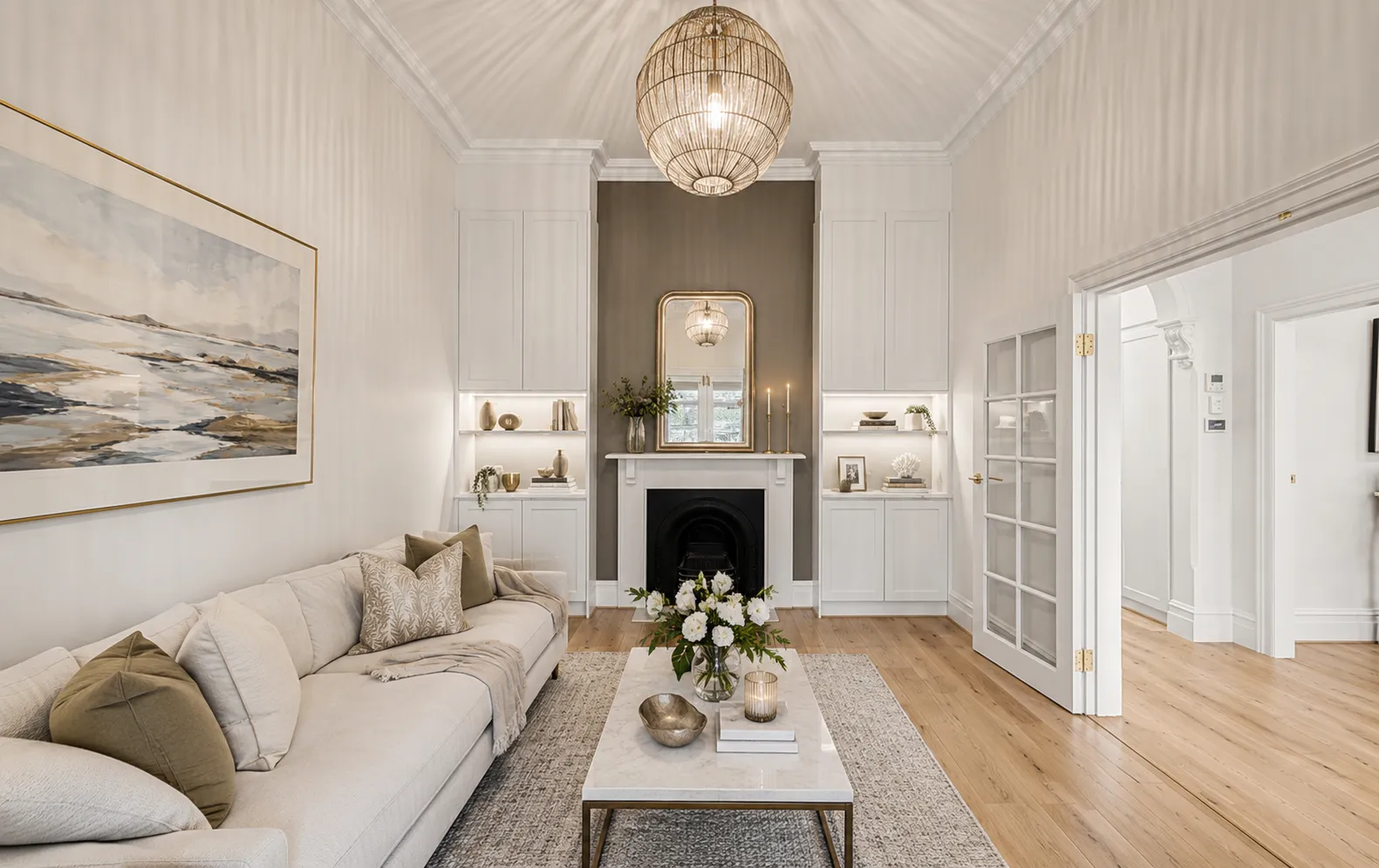Front sitting room of the original villa with a restored fireplace, ornate ceiling and French doors at 84 Toorak Gardens