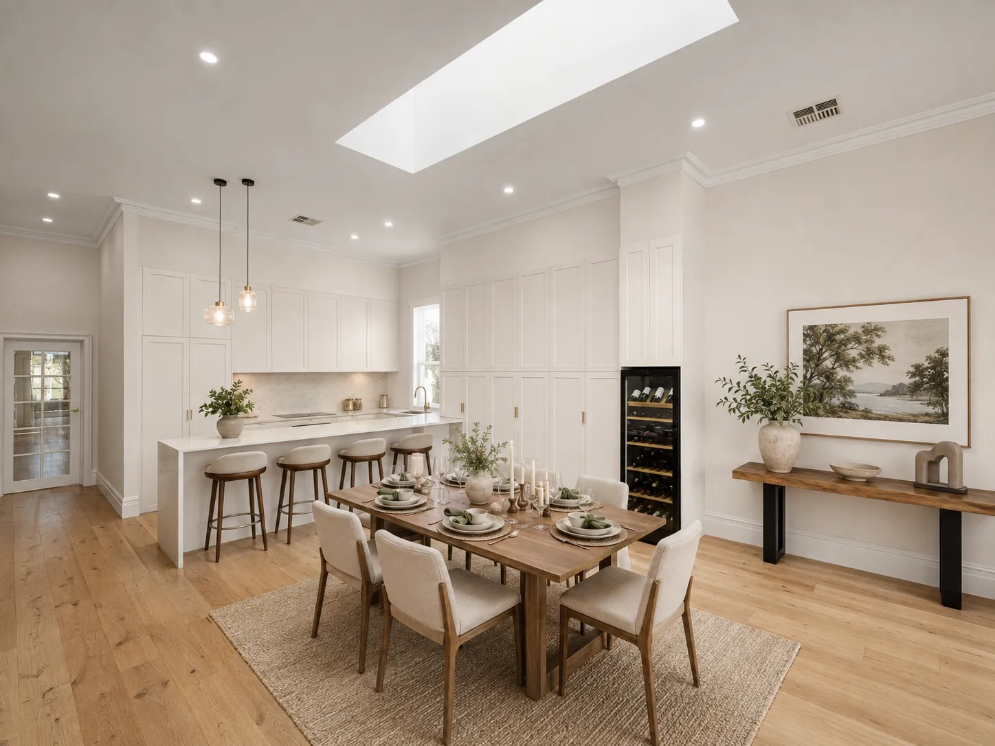 Kitchen and dining space beneath a skylight, with a stone island bench and integrated wine fridge at 84 Toorak Gardens