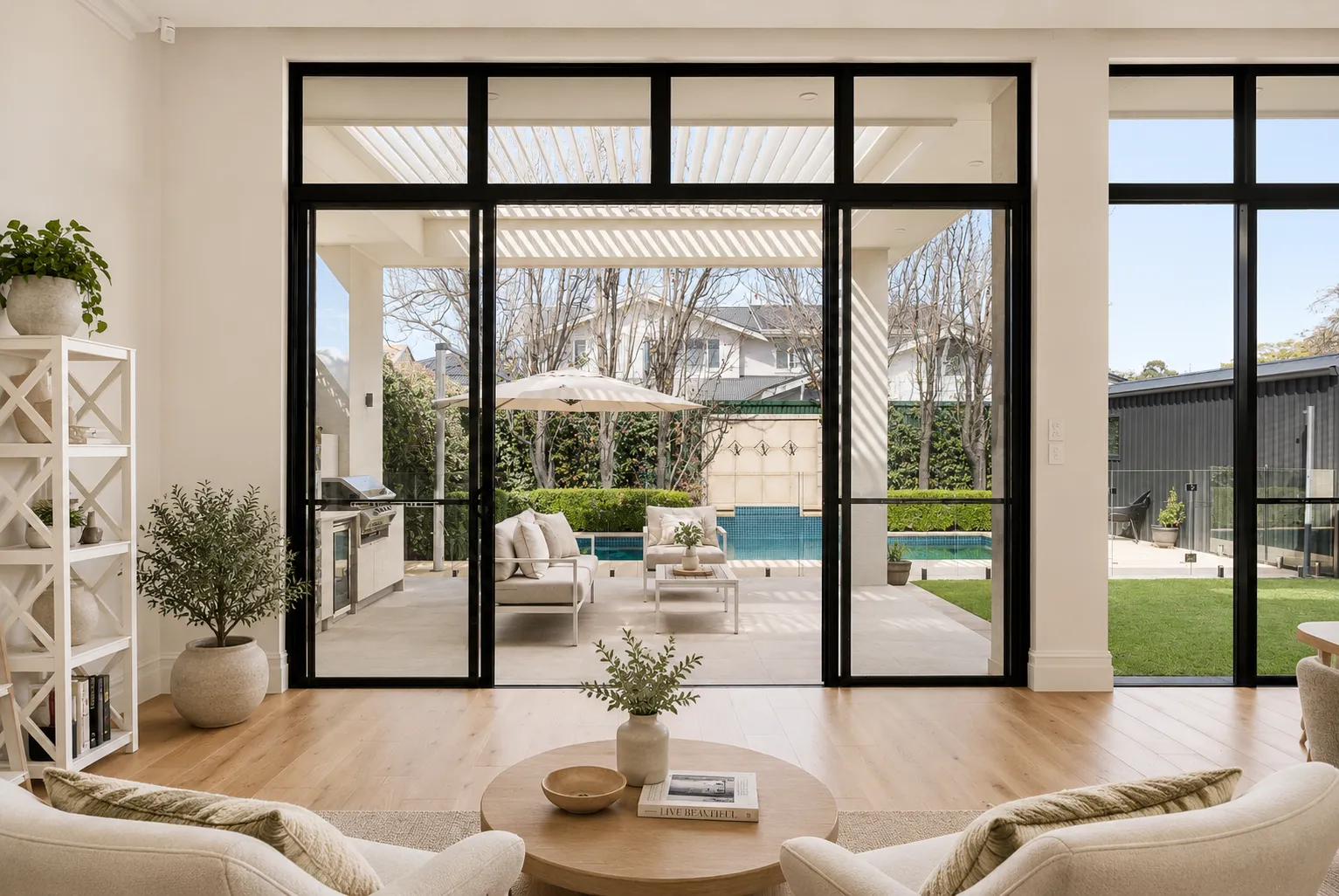 Steel-framed glazing opening the living room to the alfresco, garden and pool at 84 Toorak Gardens