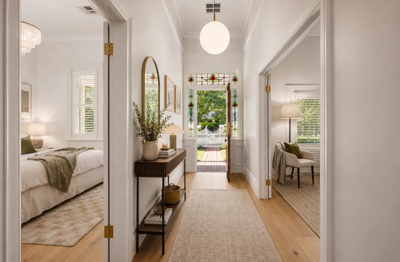 Central hallway of the villa looking toward the leadlight entry, with bedrooms opening to either side at 84 Toorak Gardens