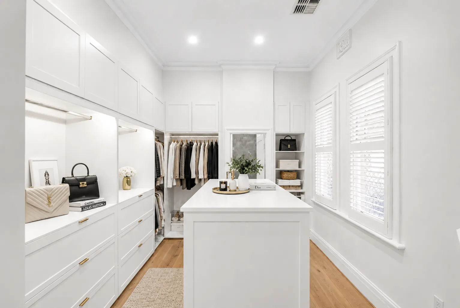 Walk-in robe with white joinery, a central island and plantation shutters, created from a former bedroom at 84 Toorak Gardens
