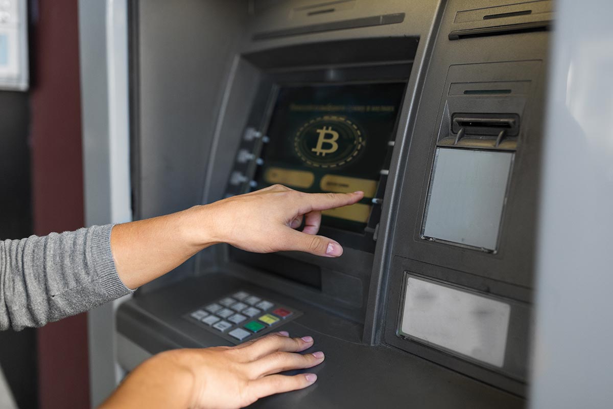 Woman using a cryptocurrency ATM kiosk