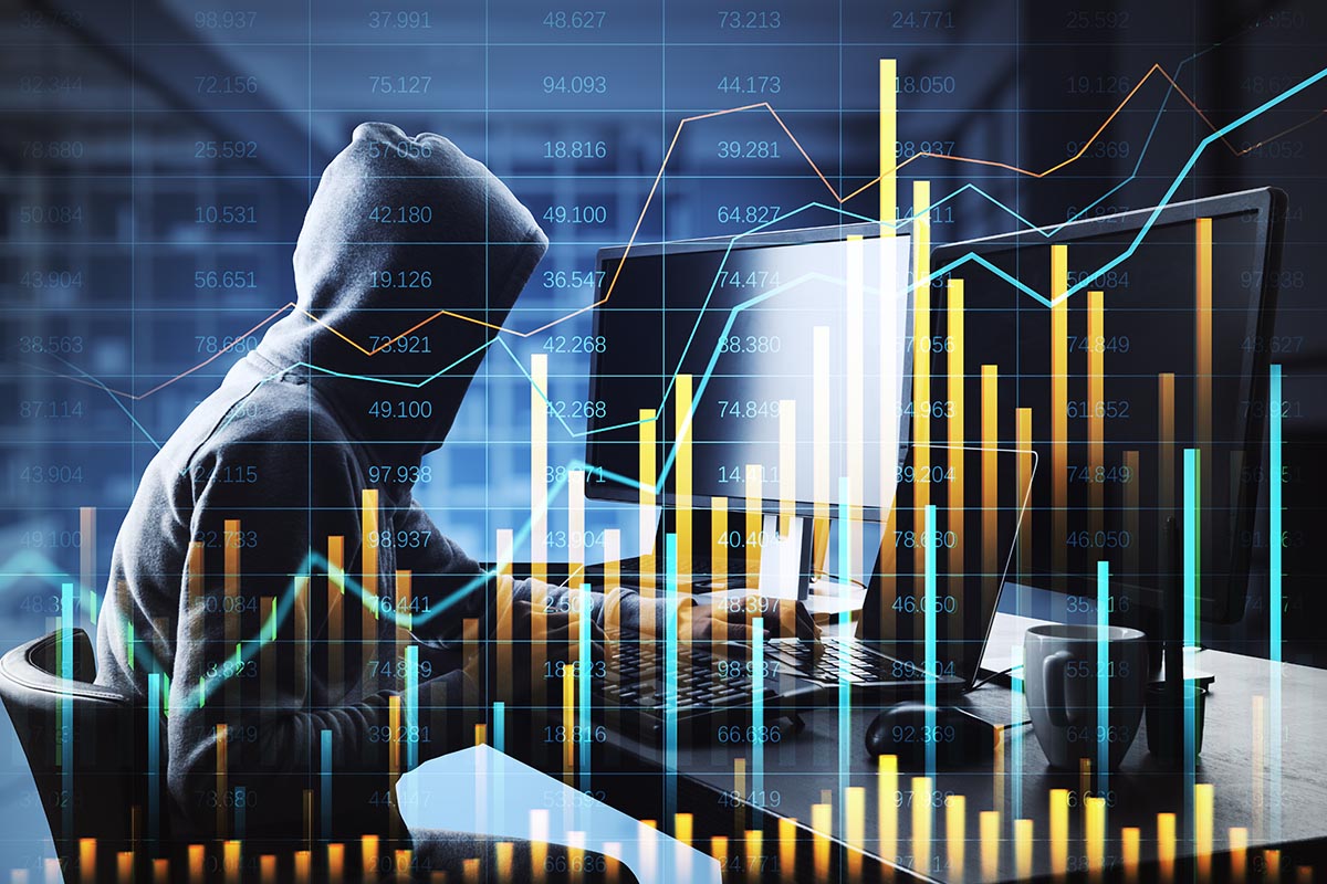 Hacker at a laptop with financial charts overlaid, representing AI-enabled crypto scam data