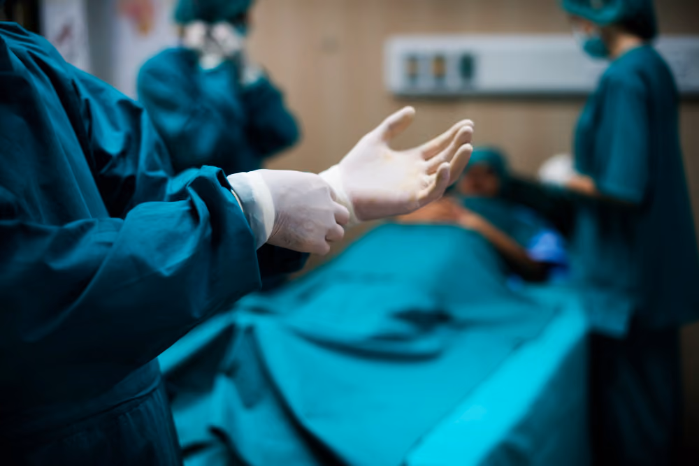 Surgeon putting on sterile gloves in the operating room