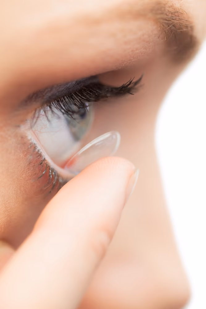 Contact lens on a fingertip, held close to the eye
