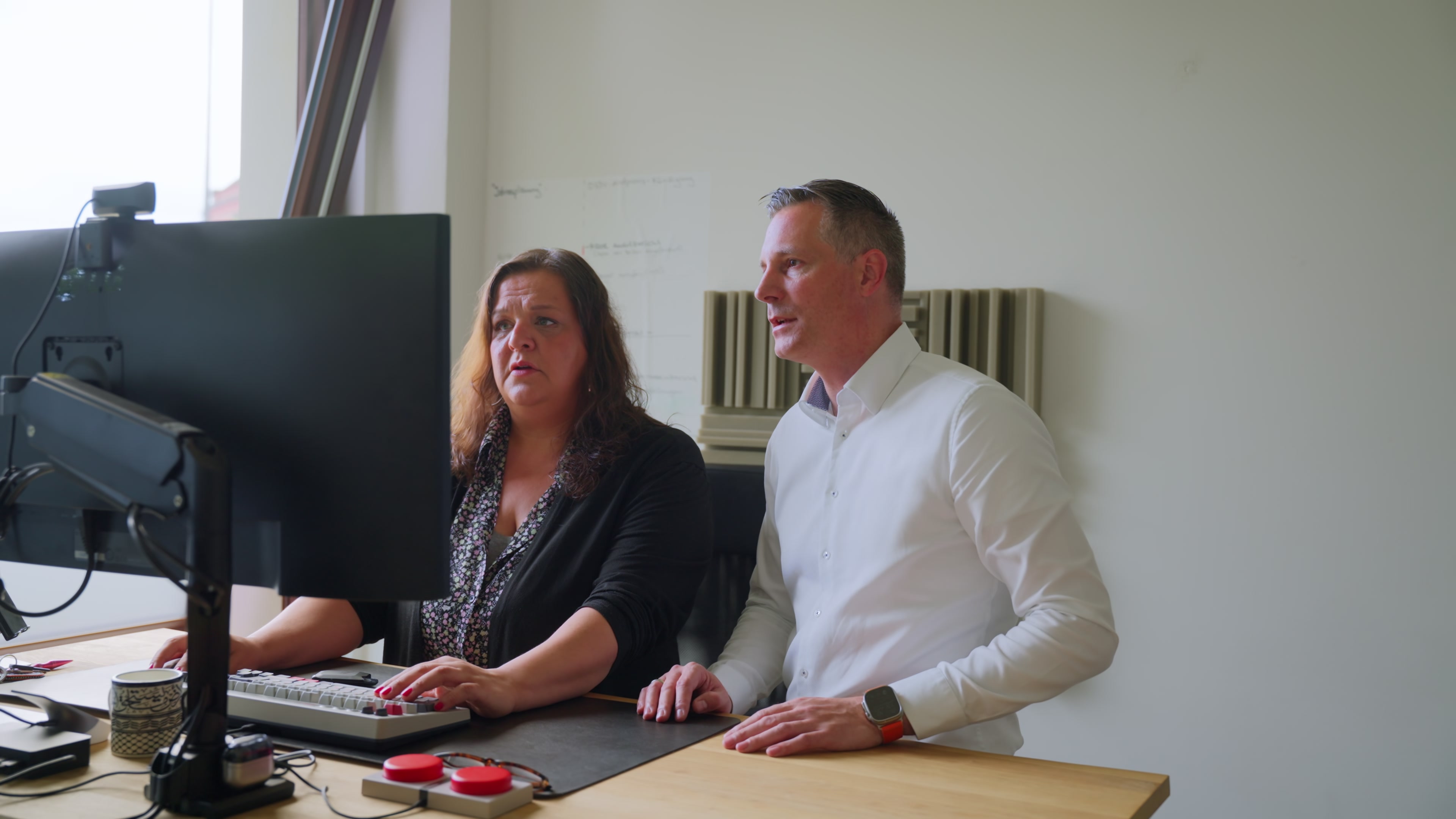 Zwei Sicherheitsexperten prüfen Systeme am Monitor