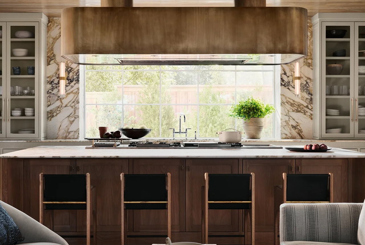 Modern kitchen island with four wooden stools, marble countertop, gas stove, and large window.