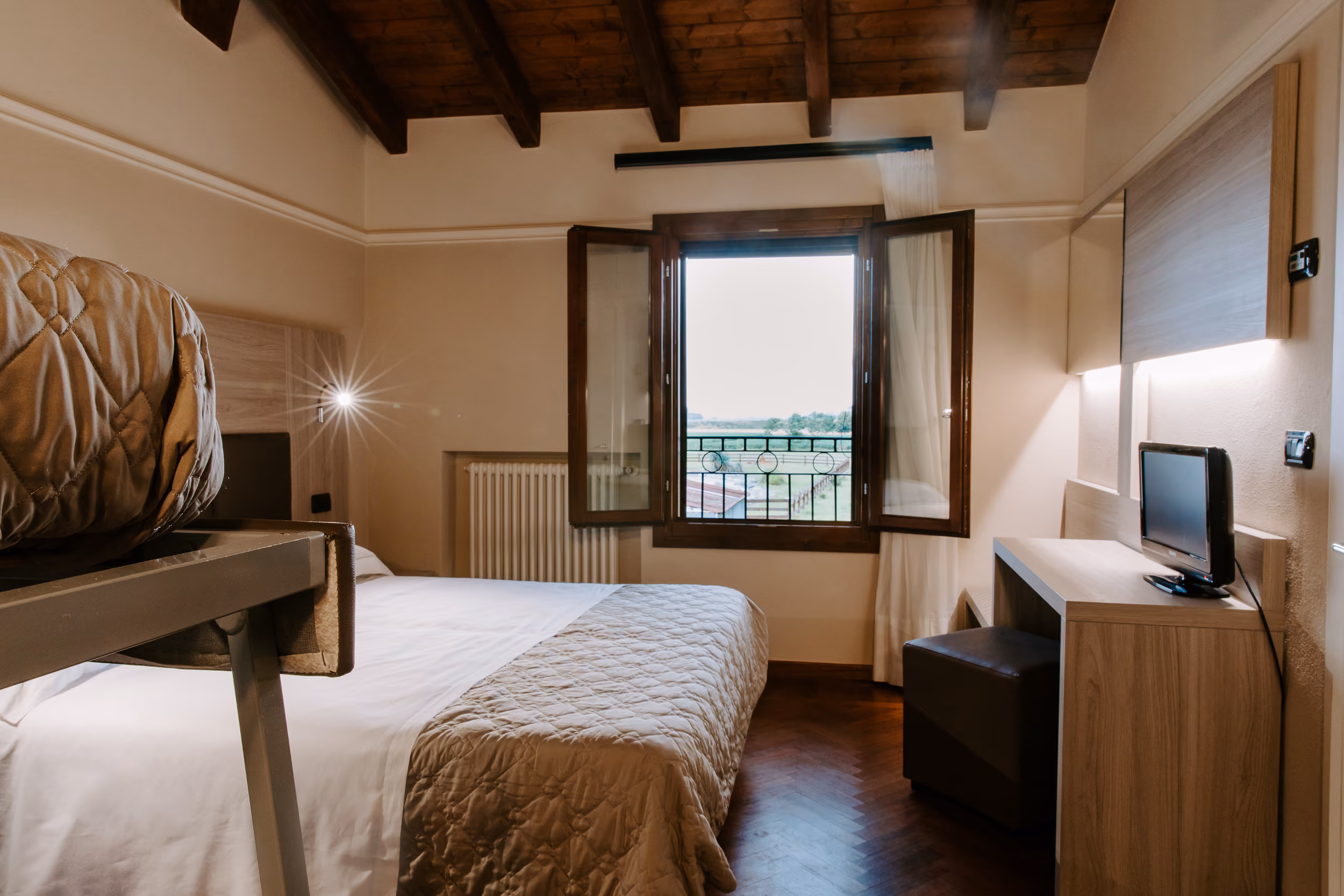 Camera Family ben organizzata con letto matrimoniale, area salotto e letto per bambini.