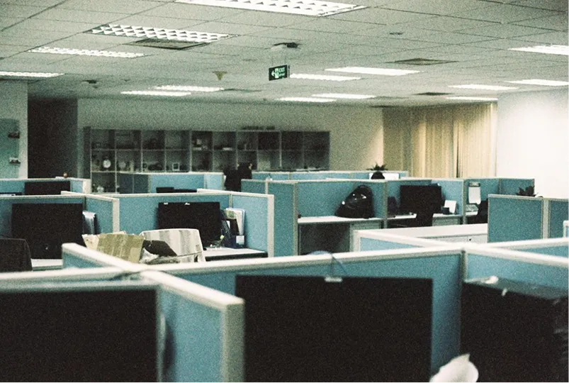 Open space d'entreprise désert avec des postes de travail cloisonnés